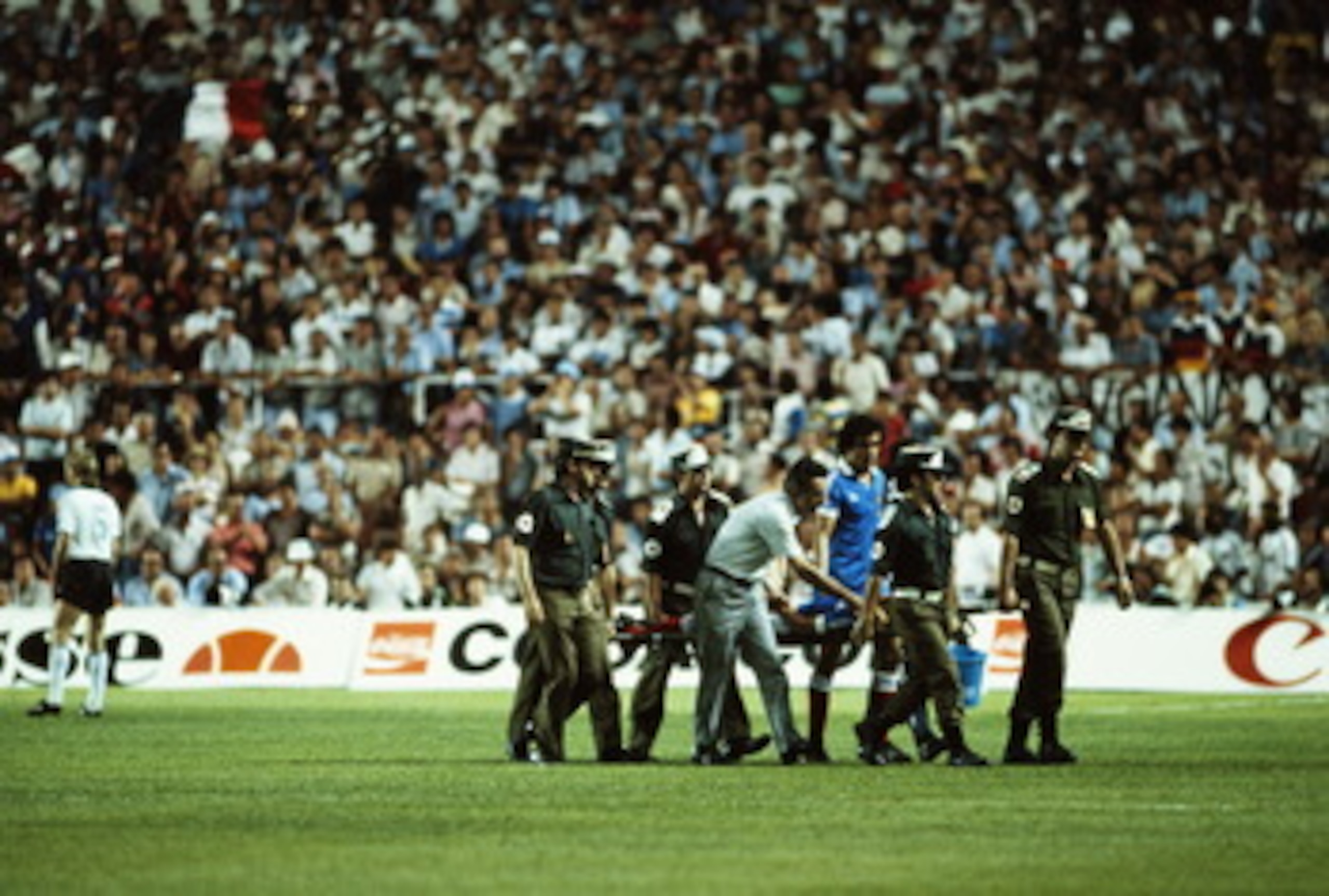 Patrick Battiston of France is carried off the field on a stretcher badly injured with a damaged vertebrae, a broken jaw and the loss of four of his front teeth after a contentious collision with goalkeeper Harald Schumacher of the Federal Republic of Ger