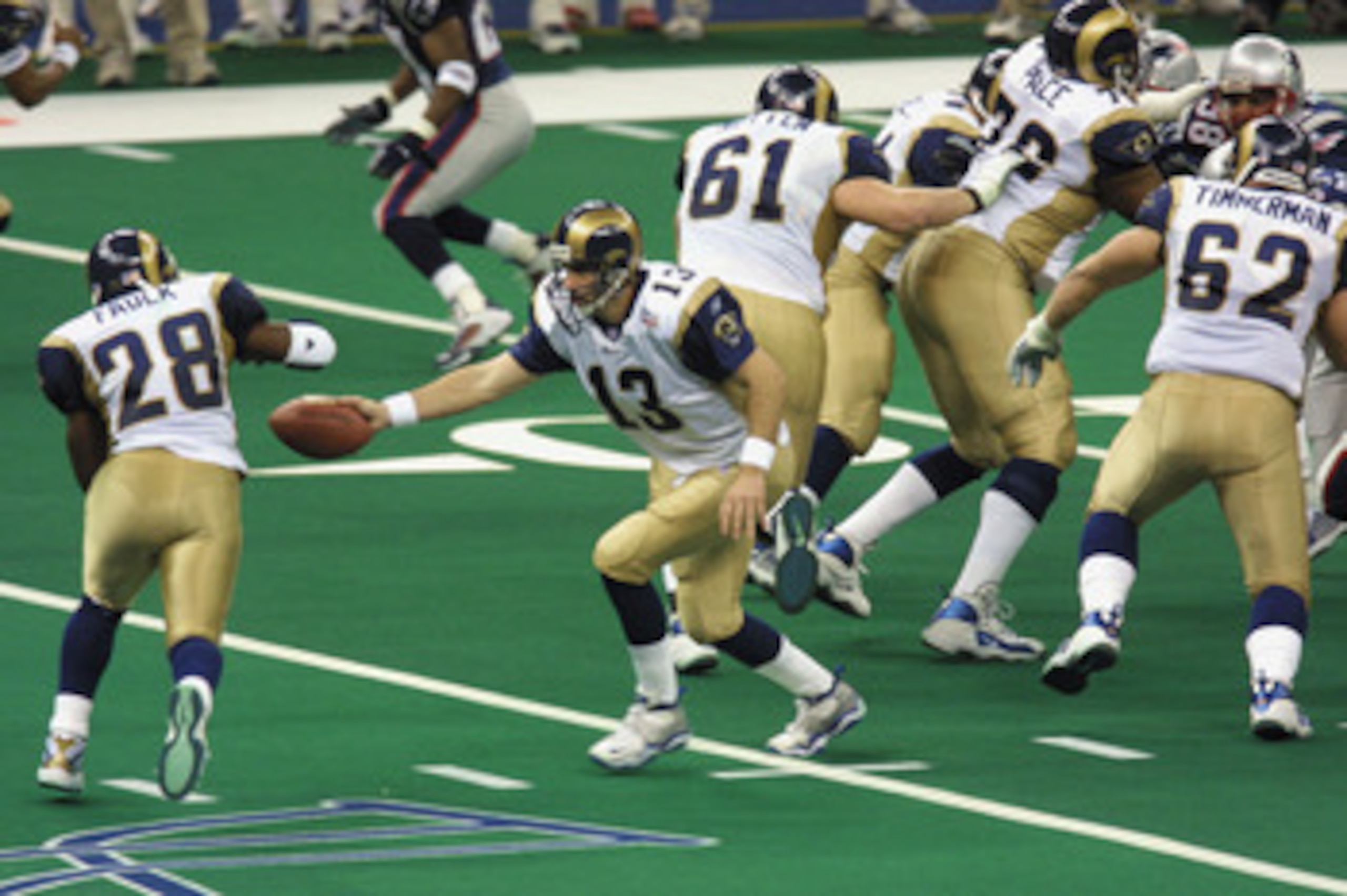 03 Feb 2002:  Quarterback Kurt Warner #13 of the St.Louis Rams  reaches for a hand off to teammate Marshall Faulk #28 during the game against the New England Patriots at Superbowl XXXVI at the Superdome in New Orleans, Louisiana.  The Patriots defeated th