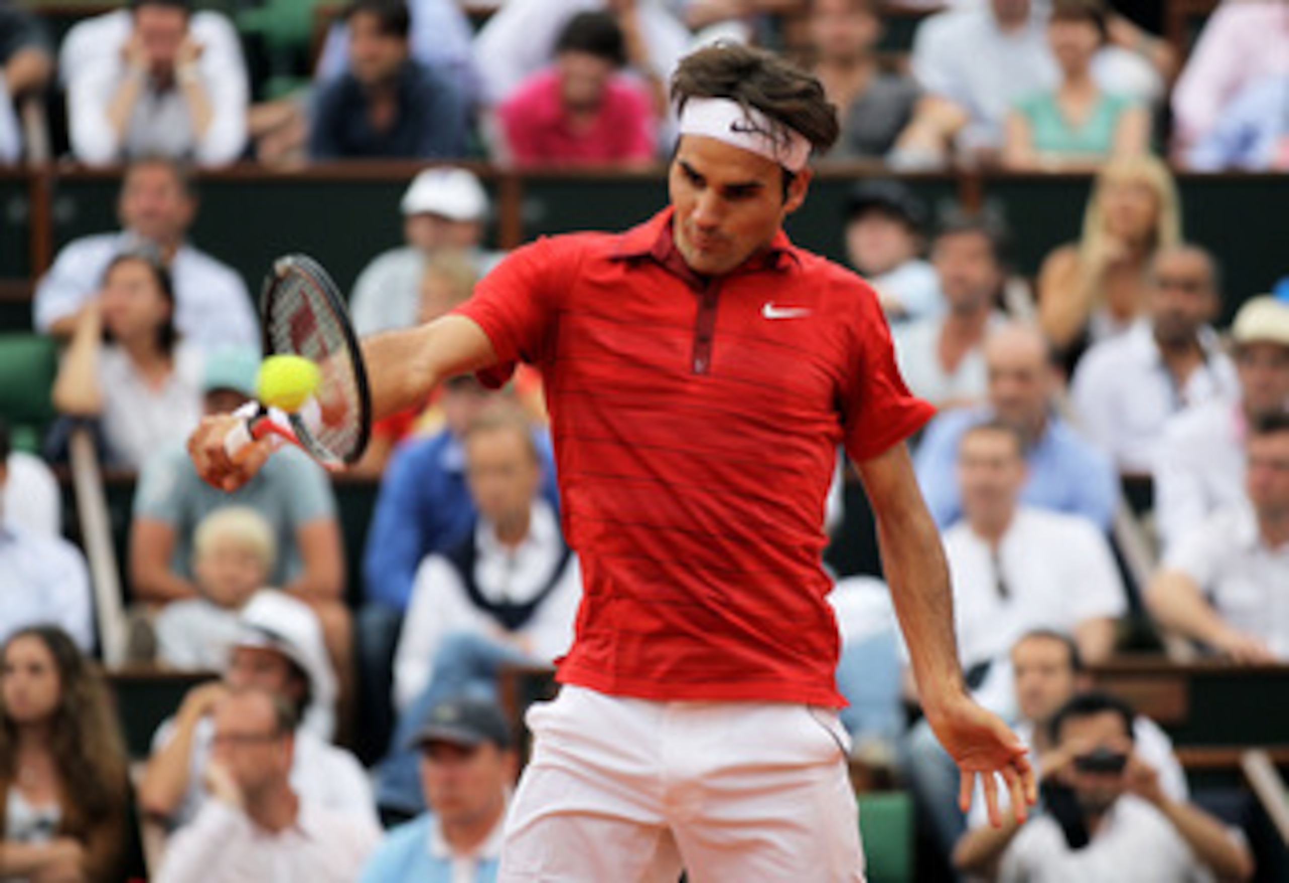 PARIS, FRANCE - JUNE 03:  Roger Federer of Switzerland hits a backhand during the men's singles semi final match between Roger Federer of Switzerland and Novak Djokovic of Serbia on day thirteen of the French Open at Roland Garros on June 3, 2011 in Paris