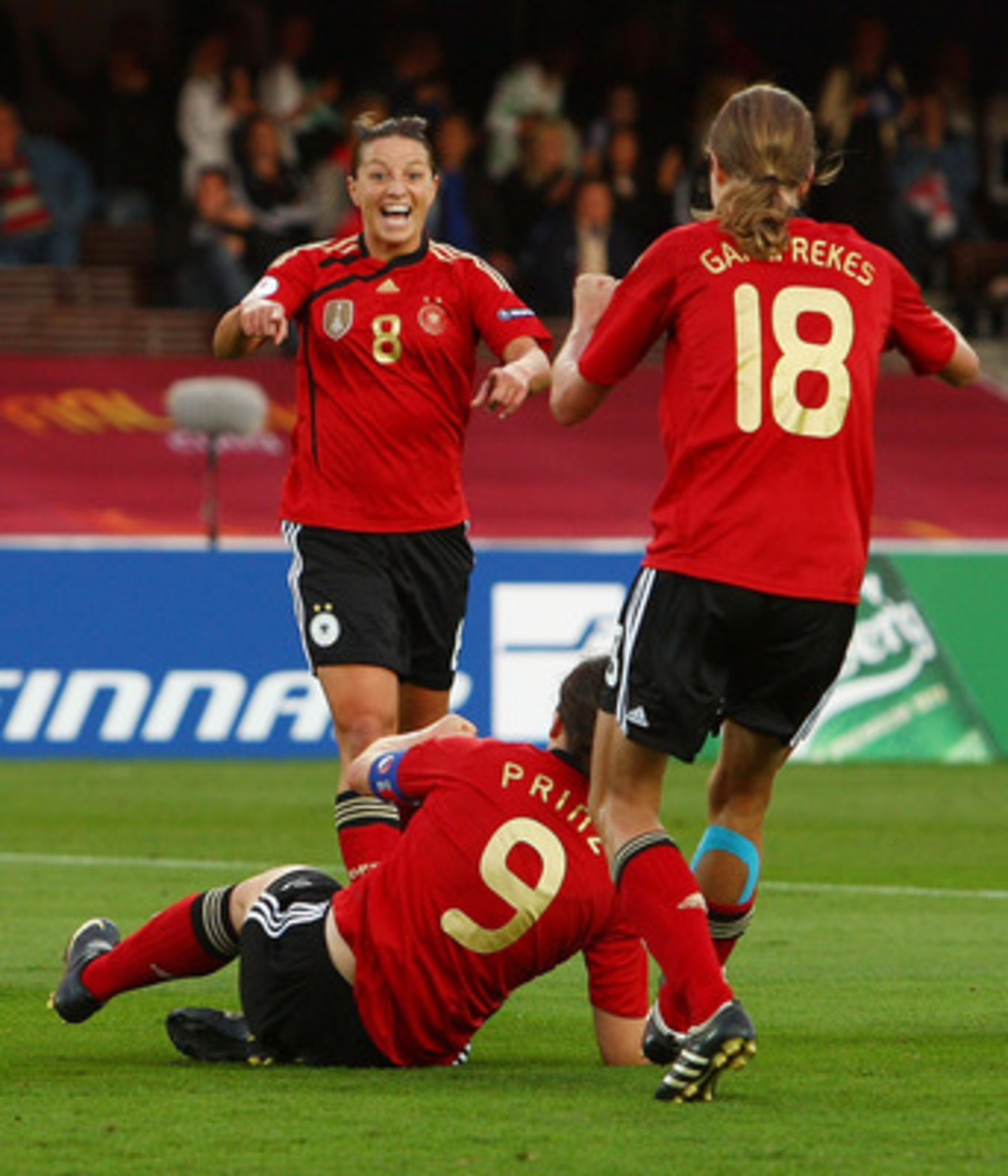 HELSINKI, FINLAND - SEPTEMBER 10:  Birgit Prinz of Germany celebrates with her team mates after scoring the first goal as Alex Scott of England lies on the floor dejected during the UEFA Women's Euro 2009 Final match between England and Germany at the Hel