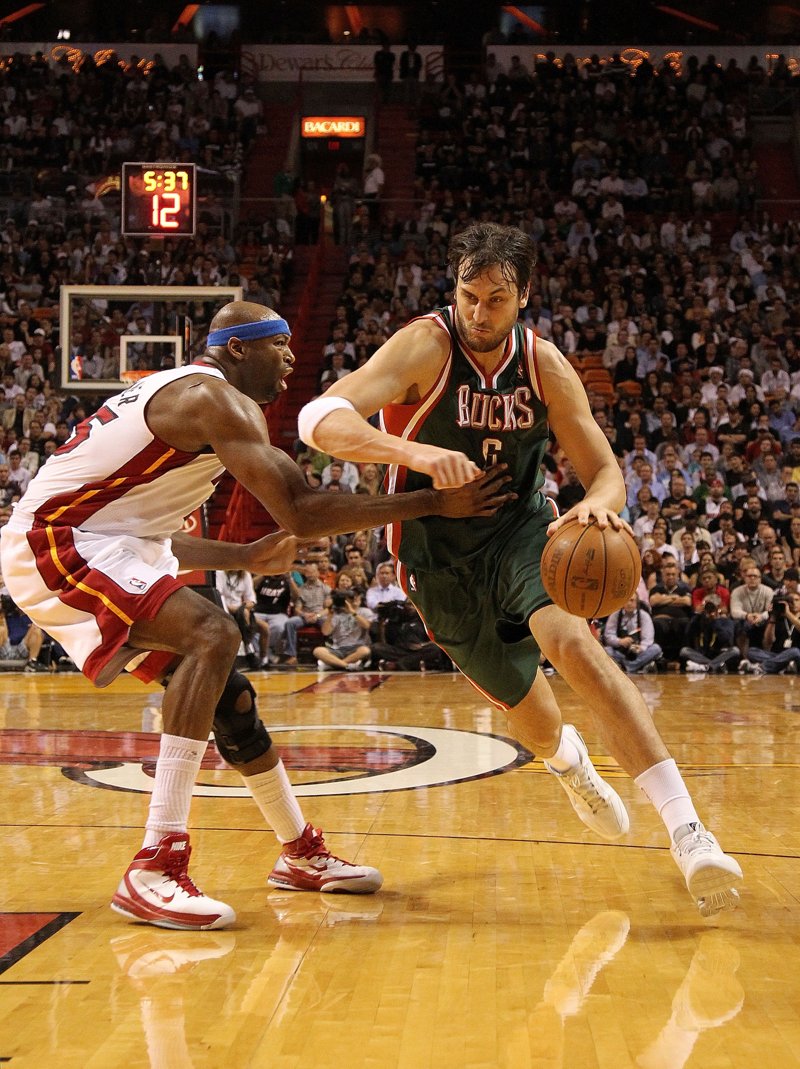 MIAMI, FL - JANUARY 04: Andrew Bogut #6 of the Milwaukee Bucks dribbles past Erick Dampier #25 of the Miami Heat during a game at American Airlines Arena on January 4, 2011 in Miami, Florida. NOTE TO USER: User expressly acknowledges and agrees that, by MIAMI, FL - JANUARY 04: Andrew Bogut #6 of the Milwaukee Bucks dribbles past Erick Dampier #25 of the Miami Heat during a game at American Airlines Arena on January 4, 2011 in Miami, Florida. NOTE TO USER: User expressly acknowledges and agrees that, by