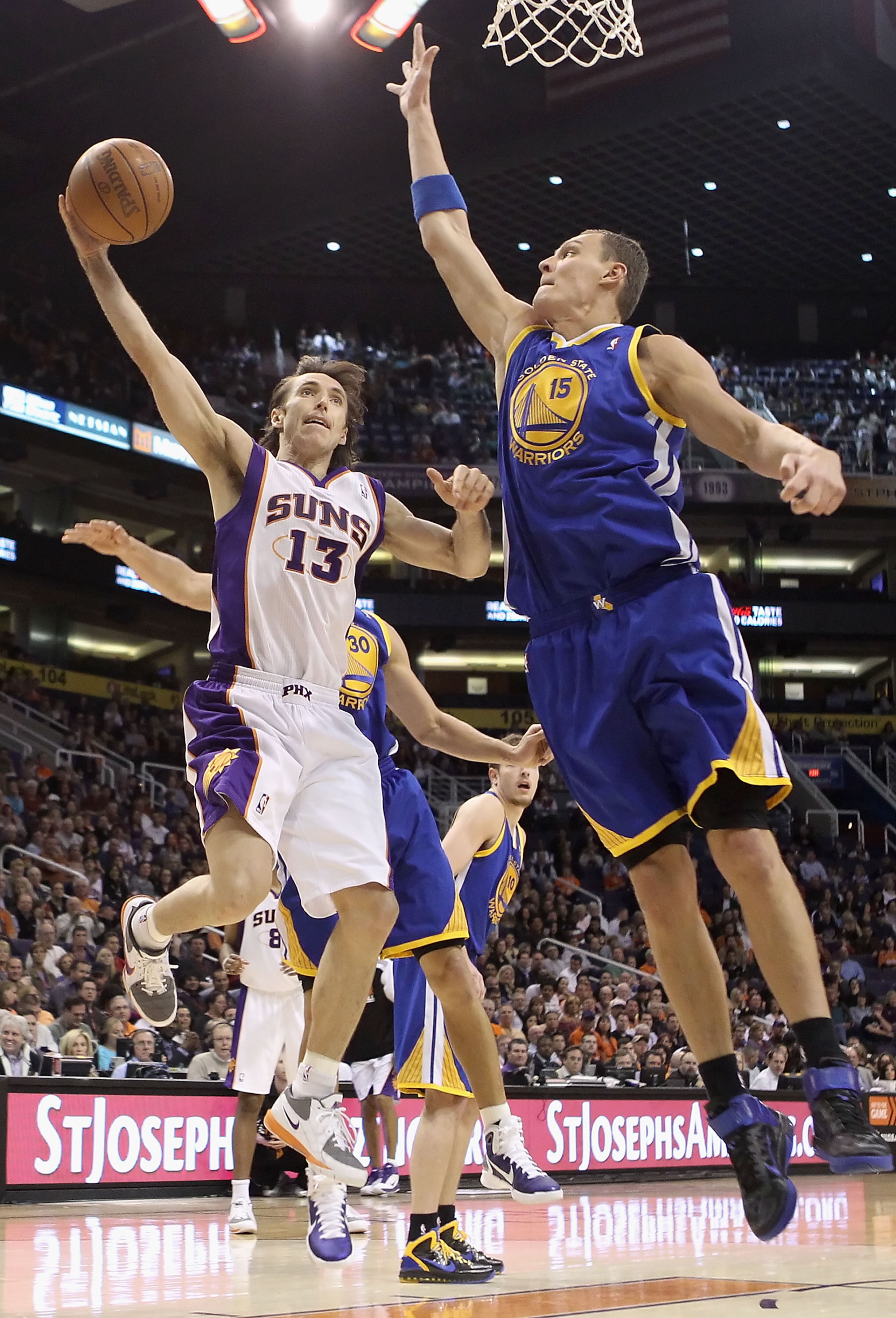 PHOENIX, AZ - FEBRUARY 10: Steve Nash #13 of the Phoenix Suns lays up a shot past Andris Biedrins #15 of the Golden State Warriors during the NBA game at US Airways Center on February 10, 2011 in Phoenix, Arizona. NOTE TO USER: User expressly acknowledg PHOENIX, AZ - FEBRUARY 10: Steve Nash #13 of the Phoenix Suns lays up a shot past Andris Biedrins #15 of the Golden State Warriors during the NBA game at US Airways Center on February 10, 2011 in Phoenix, Arizona. NOTE TO USER: User expressly acknowledg