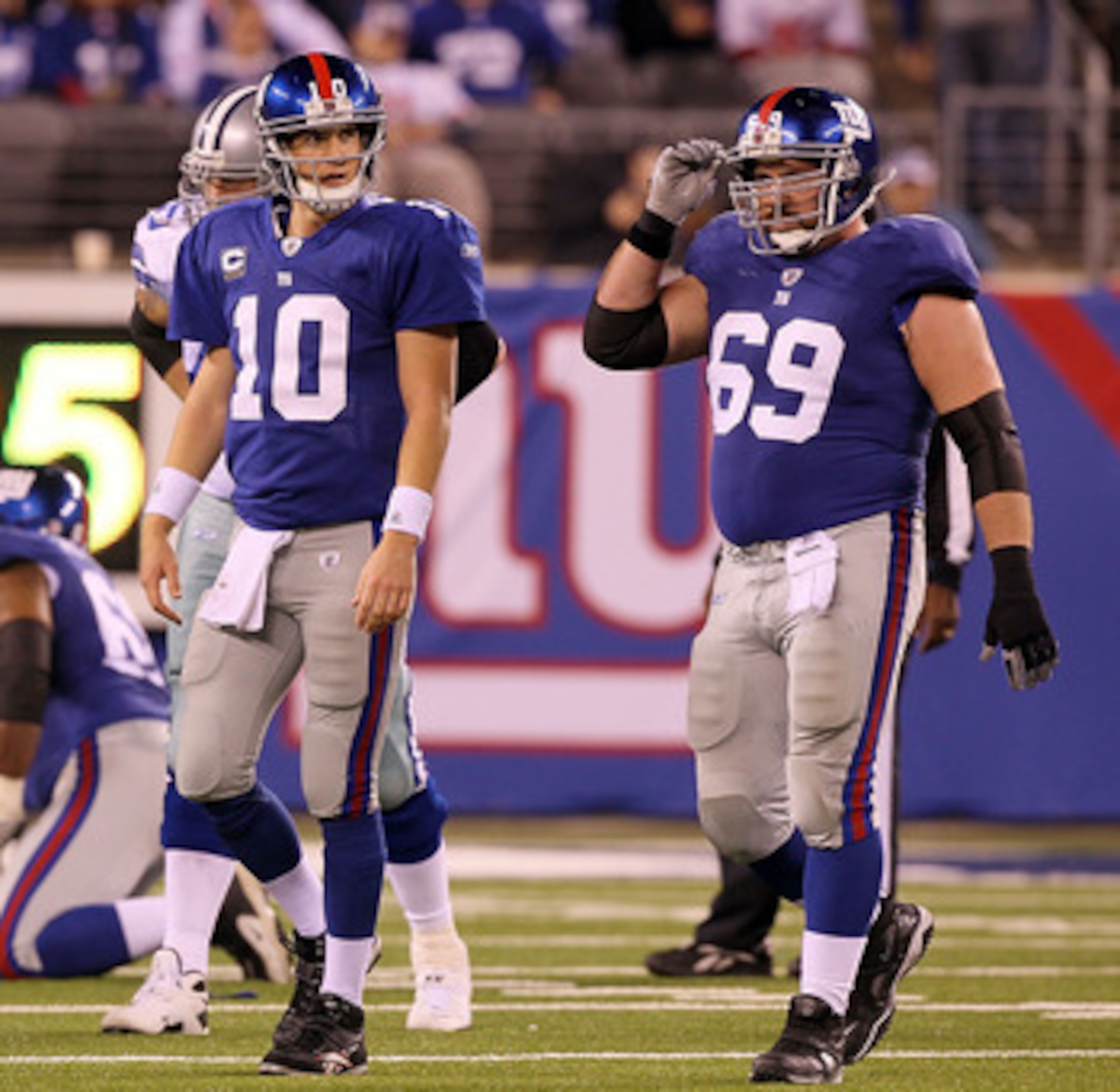 EAST RUTHERFORD, NJ - NOVEMBER 14:  Chris Snee #76, Eli Manning #10, and Rich Seubert #69 of the New York Giants walk off the field after losing the ball on a fumble in the fourth quarter against of the Dallas Cowboys on November 14, 2010 at the New Meado