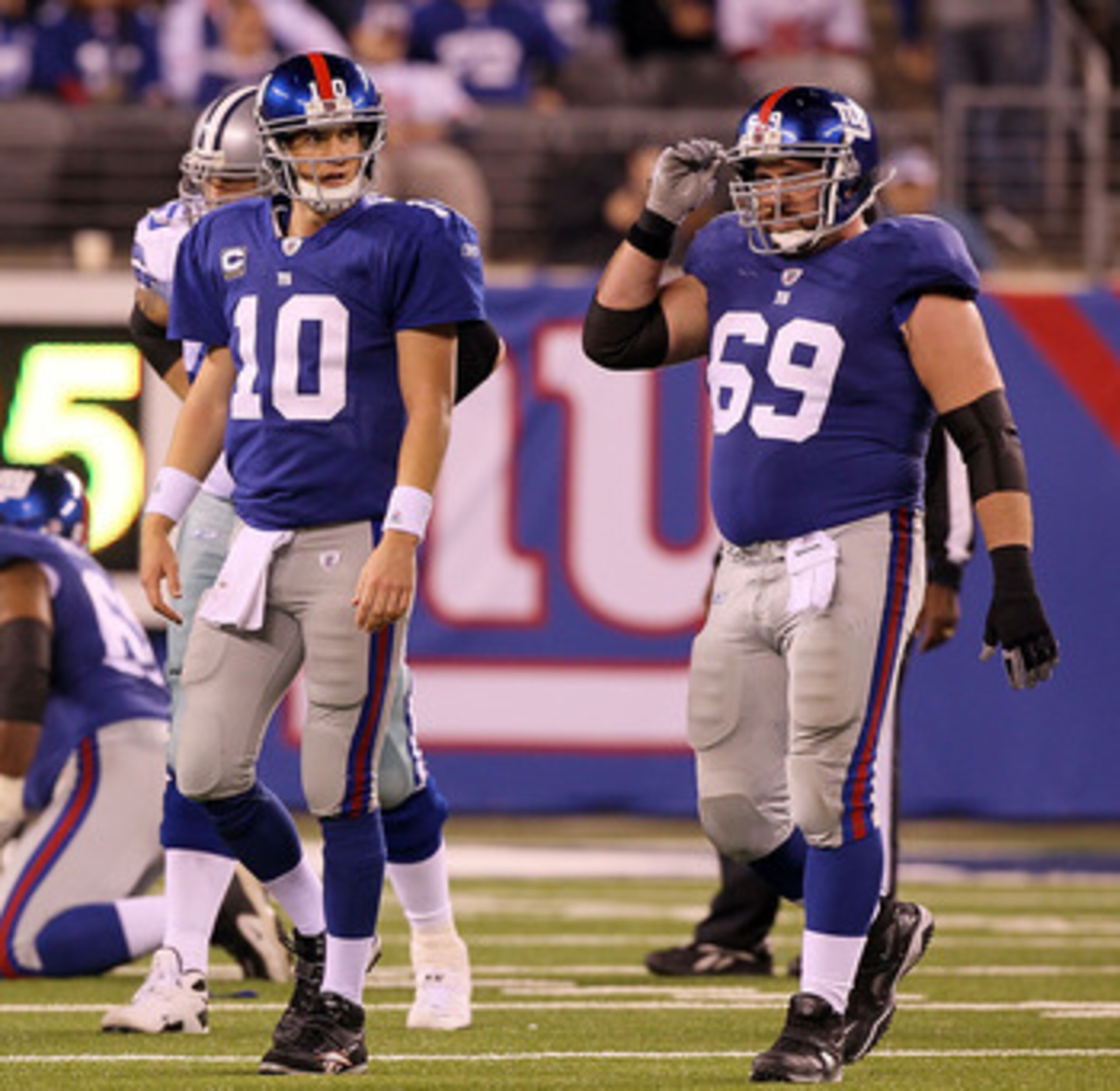 EAST RUTHERFORD, NJ - NOVEMBER 14:  Chris Snee #76, Eli Manning #10, and Rich Seubert #69 of the New York Giants walk off the field after losing the ball on a fumble in the fourth quarter against of the Dallas Cowboys on November 14, 2010 at the New Meado