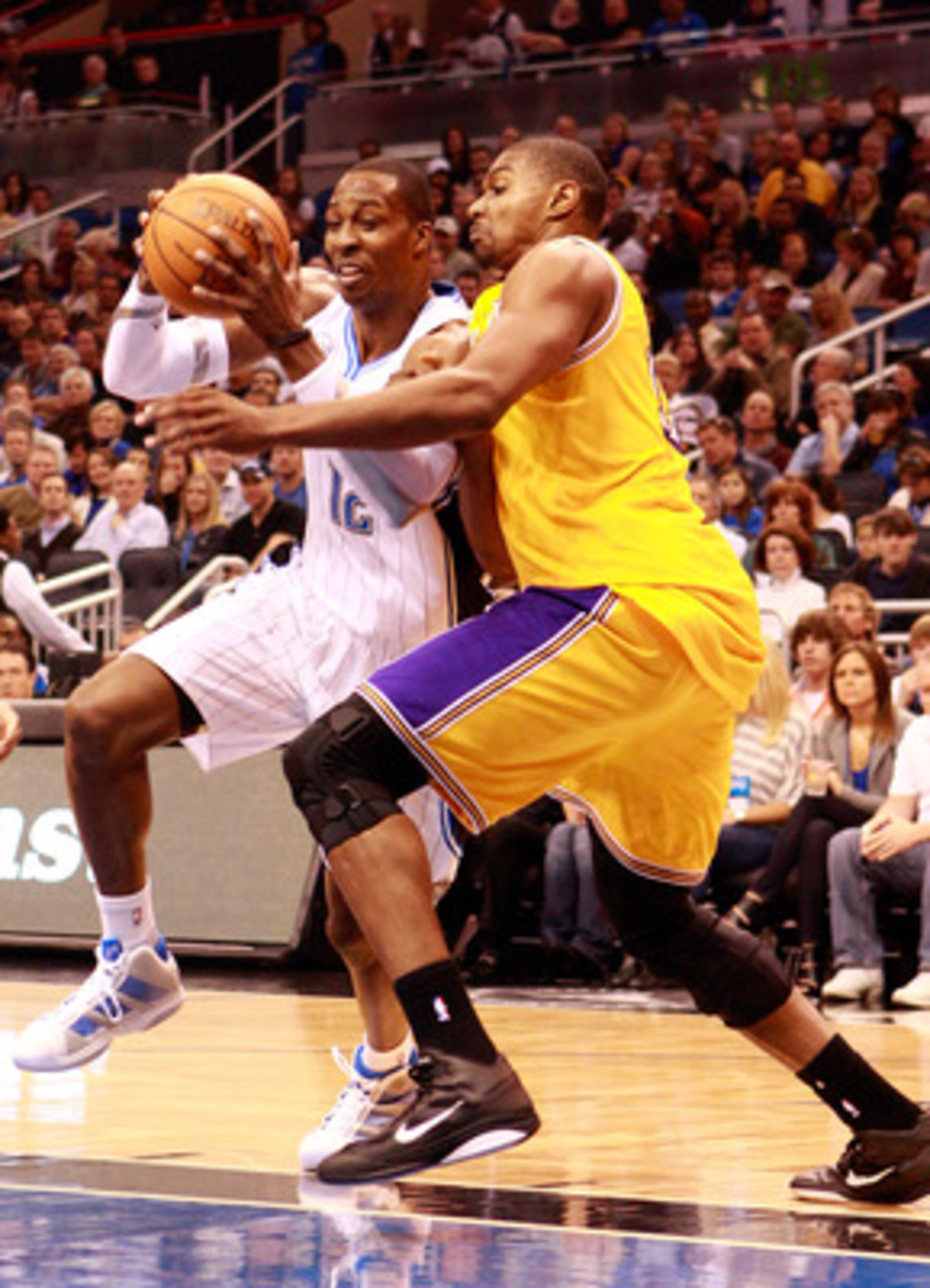ORLANDO, FL - FEBRUARY 13: Dwight Howard #12 of the Orlando Magic drives against Andrew Bynum #17 of the Los Angeles Lakers during the game at Amway Arena on February 13, 2011 in Orlando, Florida. NOTE TO USER: User expressly acknowledges and agrees tha ORLANDO, FL - FEBRUARY 13: Dwight Howard #12 of the Orlando Magic drives against Andrew Bynum #17 of the Los Angeles Lakers during the game at Amway Arena on February 13, 2011 in Orlando, Florida. NOTE TO USER: User expressly acknowledges and agrees tha