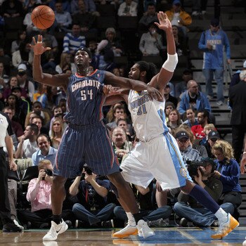 DENVER, CO - MARCH 02:  Kwame Brown #54 of the Charlotte Bobcats collects the ball against the defense of Nene #31 of the Denver Nuggets at the Pepsi Center on March 2, 2011 in Denver, Colorado. NOTE TO USER: User expressly acknowledges and agrees that, b