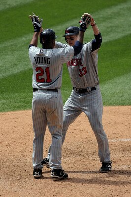 DENVER - MAY 18:  Delmon Young #21 welcomes home Justin Morneau #33 of the Minnesota Twins as they scored on Morneau's sixth inning home run against the Colorado Rockies during Interleague MLB action at Coors Field on May 18, 2008 in Denver, Colorado. The