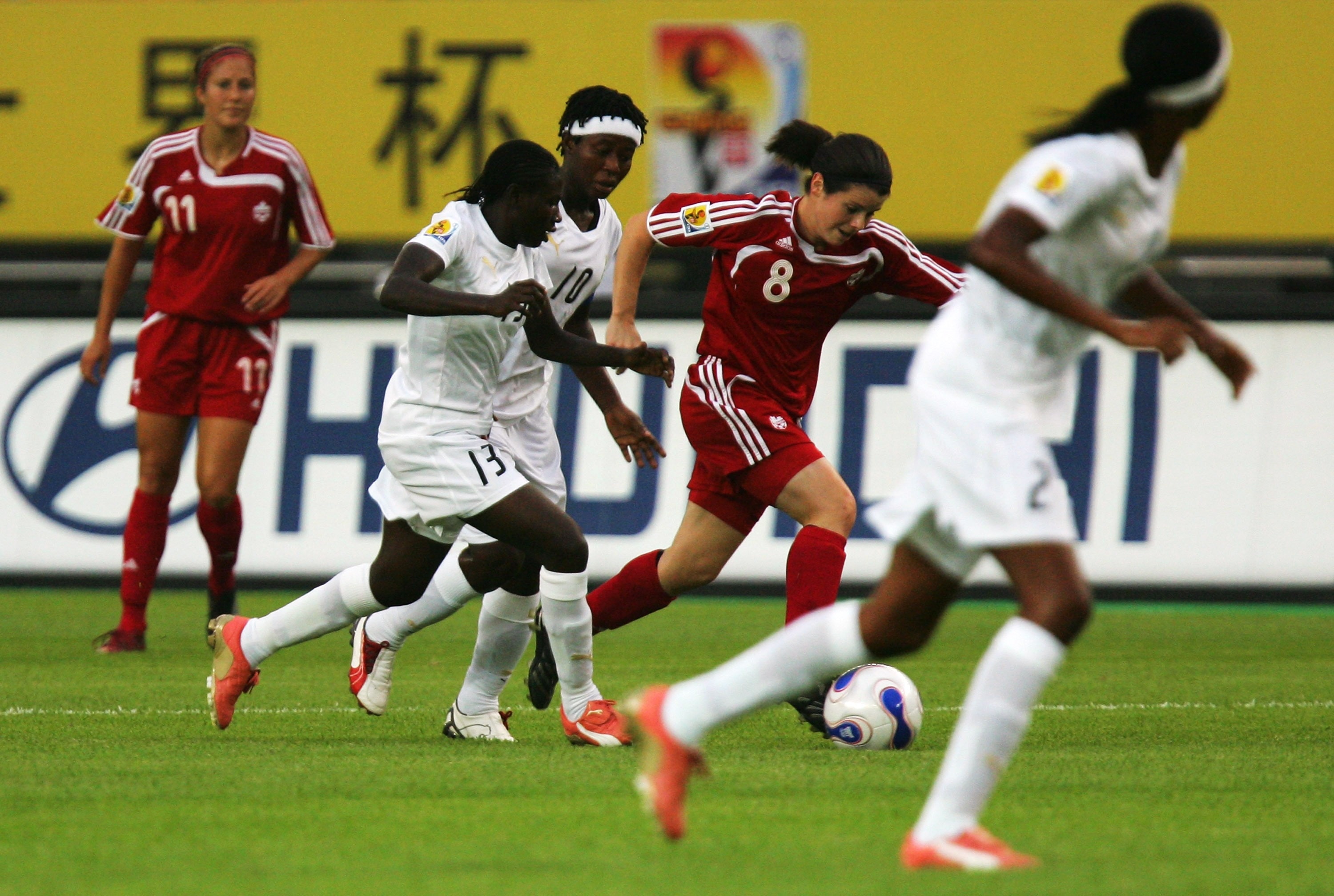 HANGZHOU, ZHEJIANG - SEPTEMBER 15:  Diana Matheson #8 of Canada battles for the ball with Yaa Avoe #13# and Adjoa Bayor #10 of Ghana during the FIFA Women's World Cup 2007 Group C match between Canada and Ghana at Hangzhou Dragon Stadium on September 15,