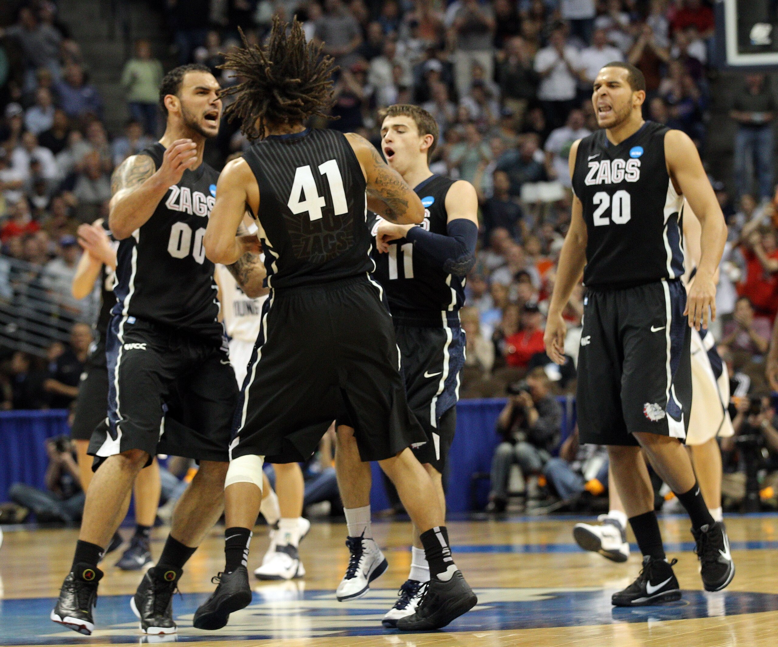 DENVER, CO - MARCH 19:  David Stockton #11, Elias Harris #20, Steven Gray #41 and Robert Sacre #00 of the Gonzaga Bulldogs celebrate after a playing against the Brigham Young Cougars during the third round of the 2011 NCAA men's basketball tournament at P