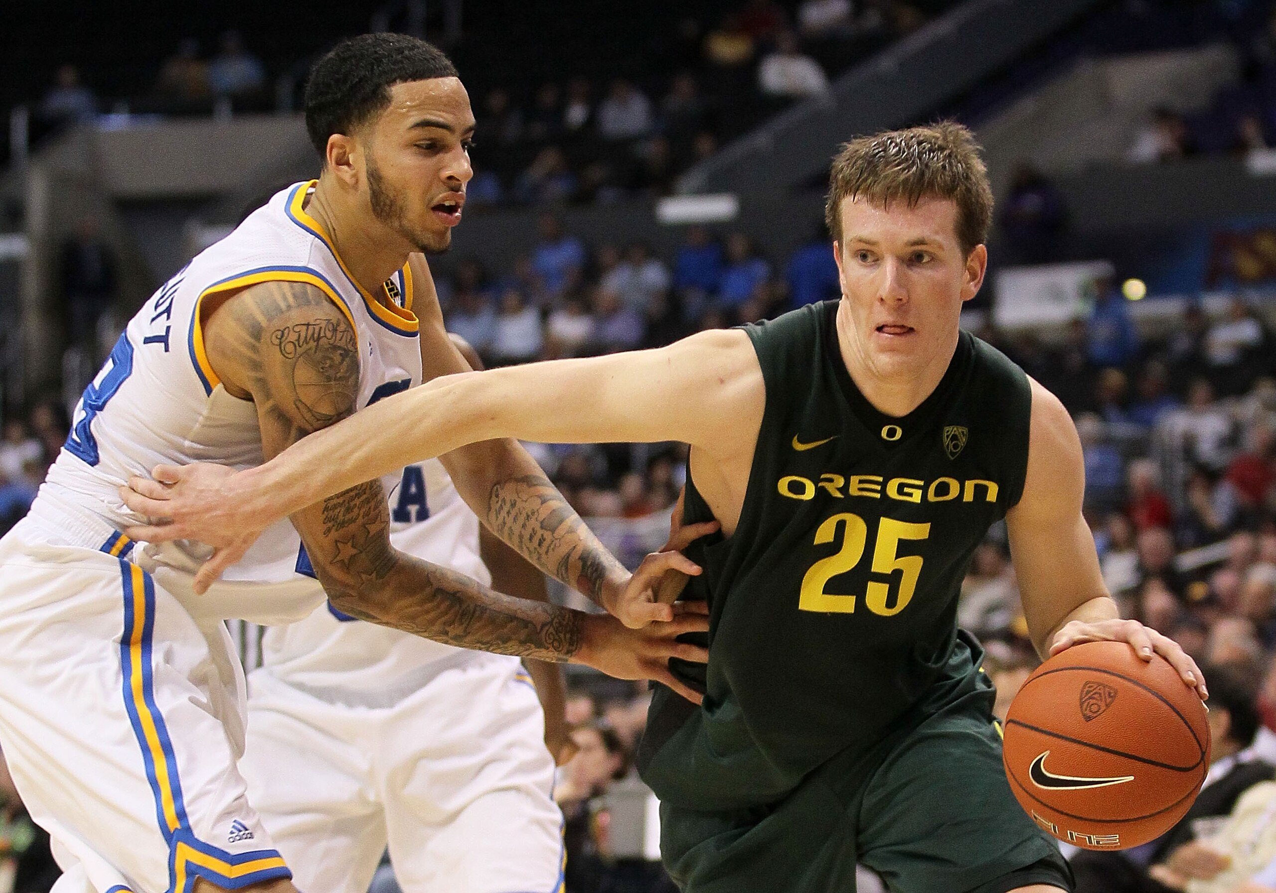 LOS ANGELES, CA - MARCH 10:  E.J. Singler #25 of the Oregon Ducks drives on Tyler Honeycutt #23 of the UCLA Bruins in the second half in the quarterfinals of the 2011 Pacific Life Pac-10 Men's Basketball Tournament at Staples Center on March 10, 2011 in L