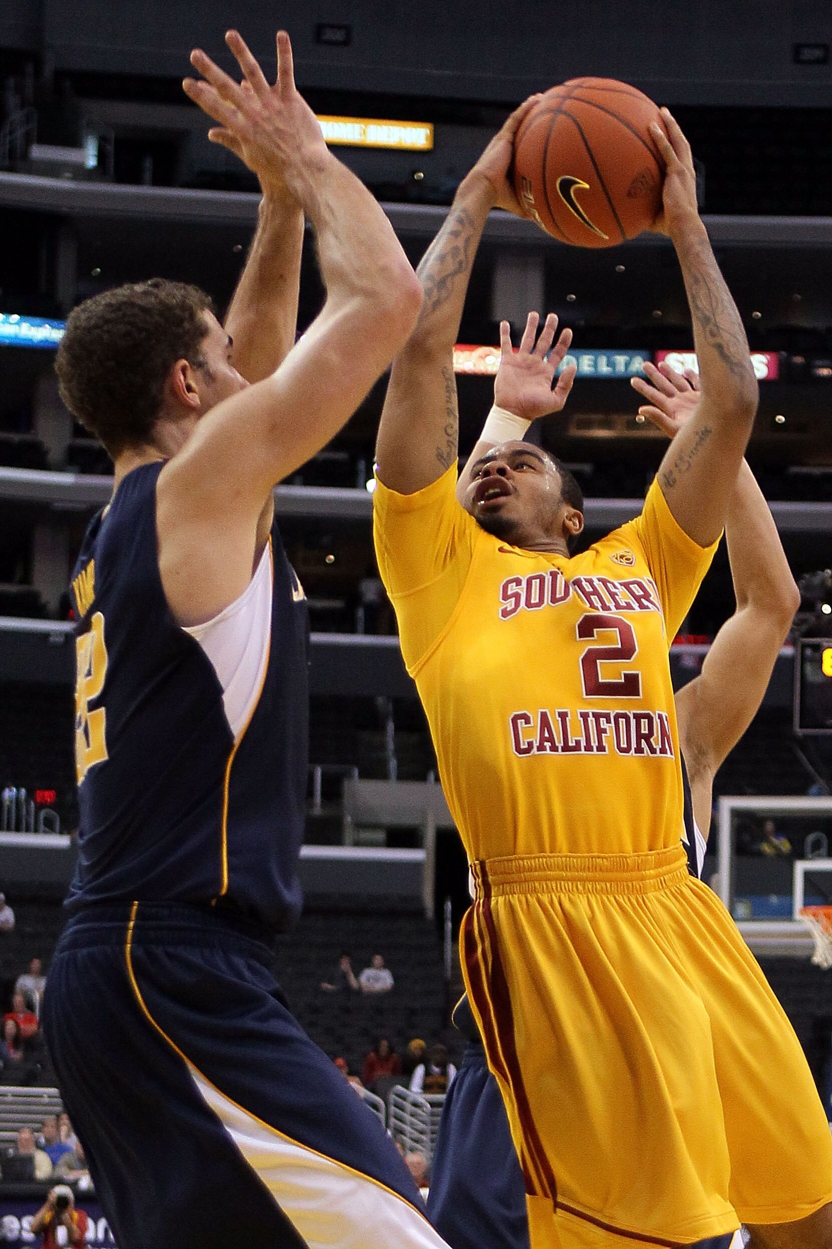 LOS ANGELES, CA - MARCH 10:  Jio Fontan #2 of the USC Trojans goes up for a shot against Harper Kamp #22 of the California Golden Bears in the first half in the quarterfinals of the 2011 Pacific Life Pac-10 Men's Basketball Tournament at Staples Center on