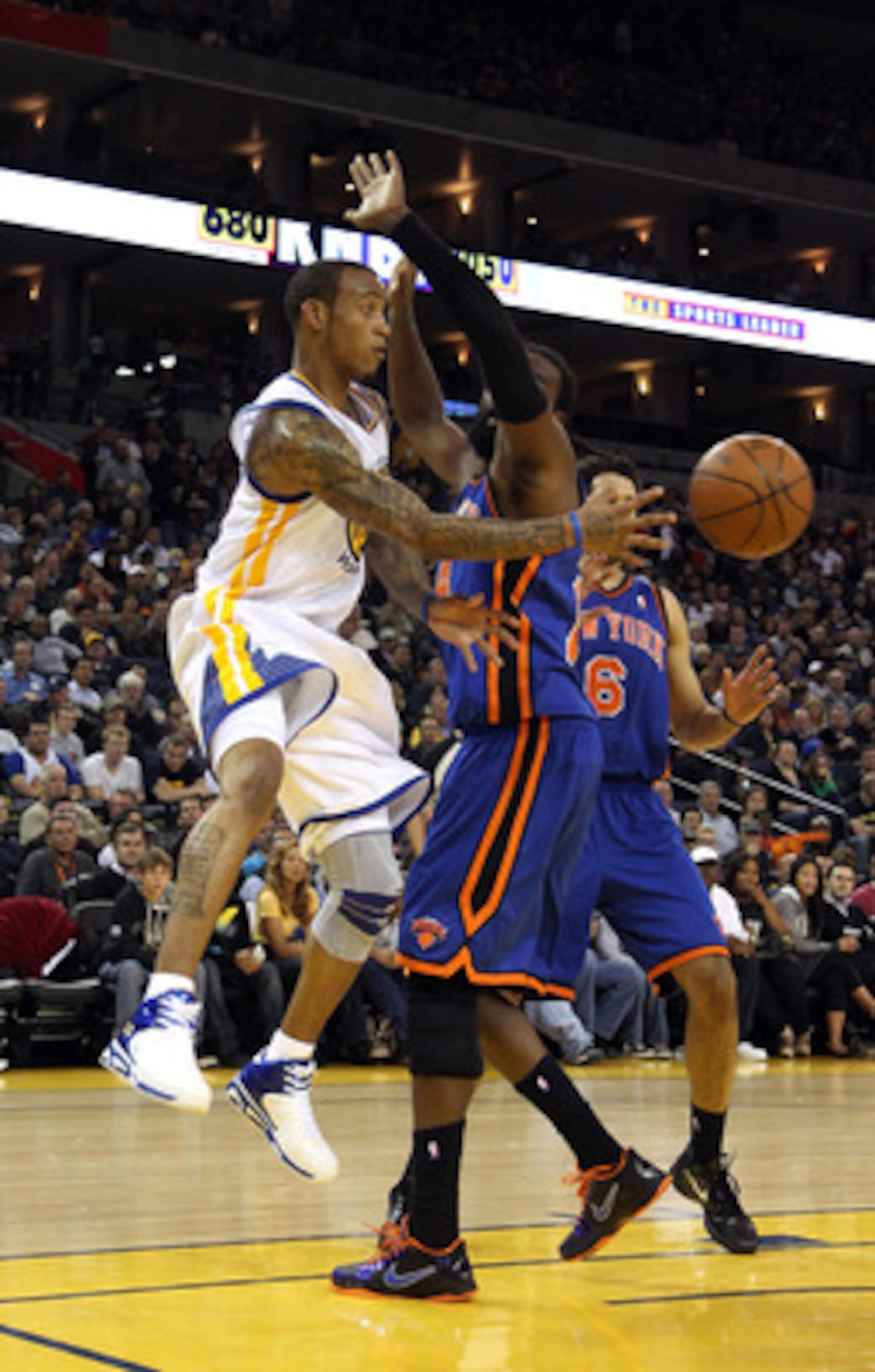 OAKLAND, CA - NOVEMBER 19:  Monta Ellis #8 of the Golden State Warriors passes around Ronny Turiaf #14 of the New York Knicks at Oracle Arena on November 19, 2010 in Oakland, California. NOTE TO USER: User expressly acknowledges and agrees that, by downlo