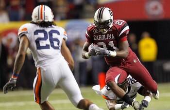 ATLANTA, GA - DECEMBER 04:  Marcus Lattimore #21 of the South Carolina Gamecocks is tackled by Daren Bates #25 of the Auburn Tigers during the 2010 SEC Championship at Georgia Dome on December 4, 2010 in Atlanta, Georgia.  (Photo by Kevin C. Cox/Getty Ima