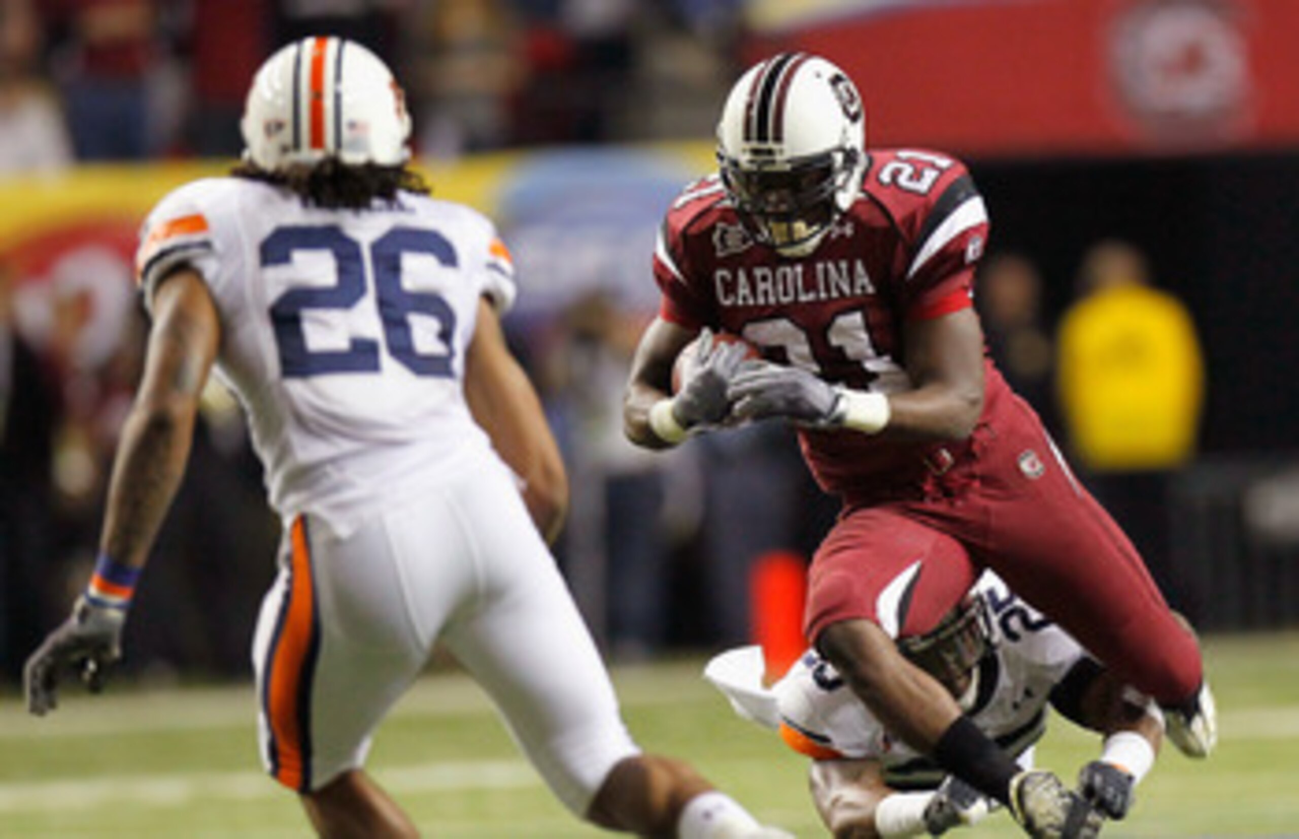 ATLANTA, GA - DECEMBER 04:  Marcus Lattimore #21 of the South Carolina Gamecocks is tackled by Daren Bates #25 of the Auburn Tigers during the 2010 SEC Championship at Georgia Dome on December 4, 2010 in Atlanta, Georgia.  (Photo by Kevin C. Cox/Getty Ima