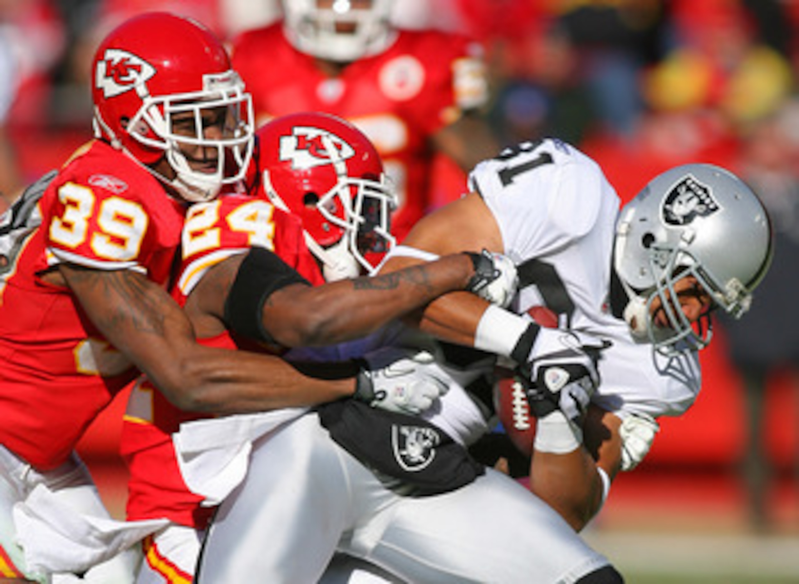KANSAS CITY, MO - JANUARY 02:  Wide receiver Chaz Schilens #81 of the Oakland Raiders is tackled by Brandon Carr #39 and Brandon Flowers #24 of the Kansas City Chiefs in a game at Arrowhead Stadium on January 2, 2011 in Kansas City, Missouri.  (Photo by T