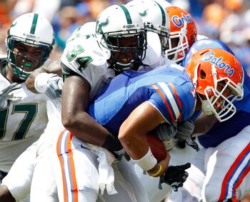GAINESVILLE, FL - SEPTEMBER 11:  Quarterback Trey Burton #13 of the Florida Gators is tackled by Devekeyan Lattimore #34 of the South Florida Bulls  during a game at Ben Hill Griffin Stadium on September 11, 2010 in Gainesville, Florida.  (Photo by Sam Gr