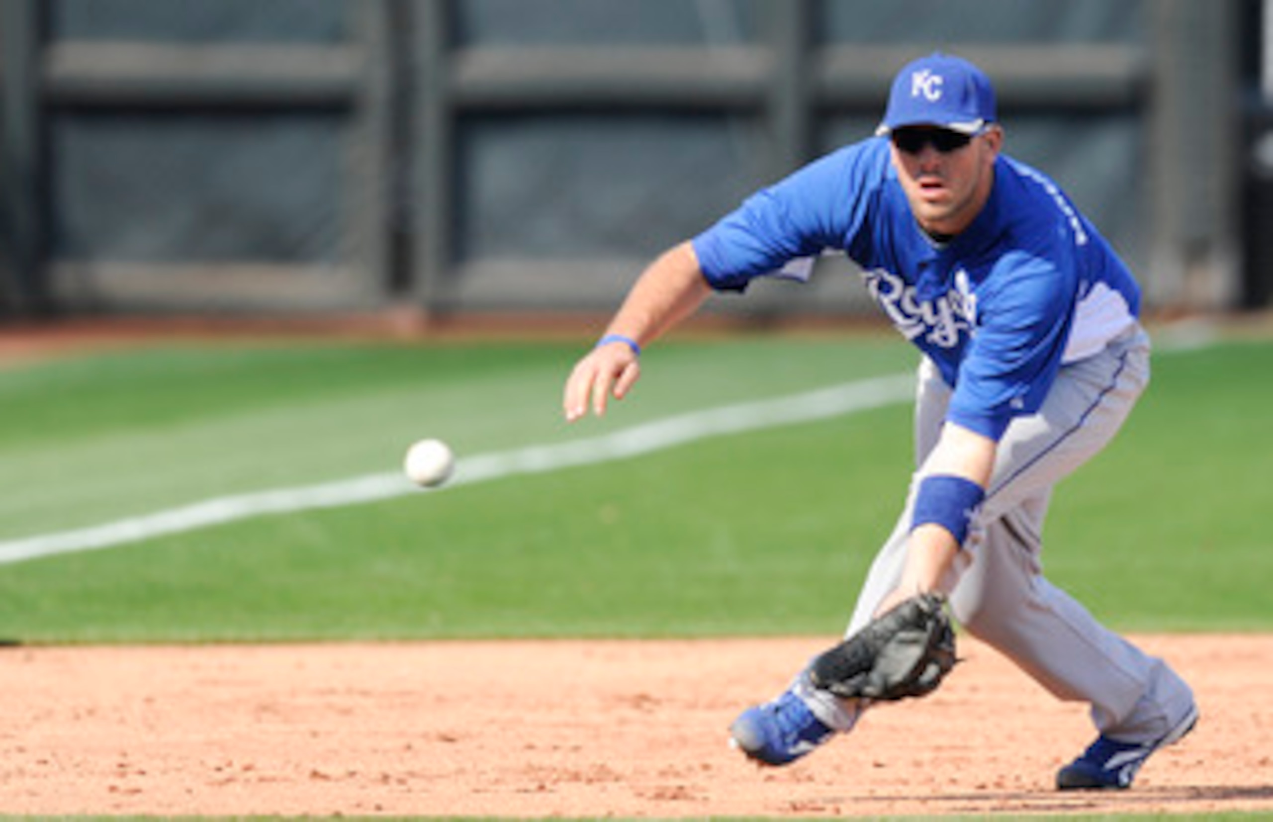 SURPISE, AZ - FEBRUARY 27: Mike Moustakas #8 of the Kansas City Royals field a ground ball during a spring training game against the Texas Rangers at Surprise Stadium on February 27, 2011 in Surprise, Arizona. (Photo by Rob Tringali/Getty Images)