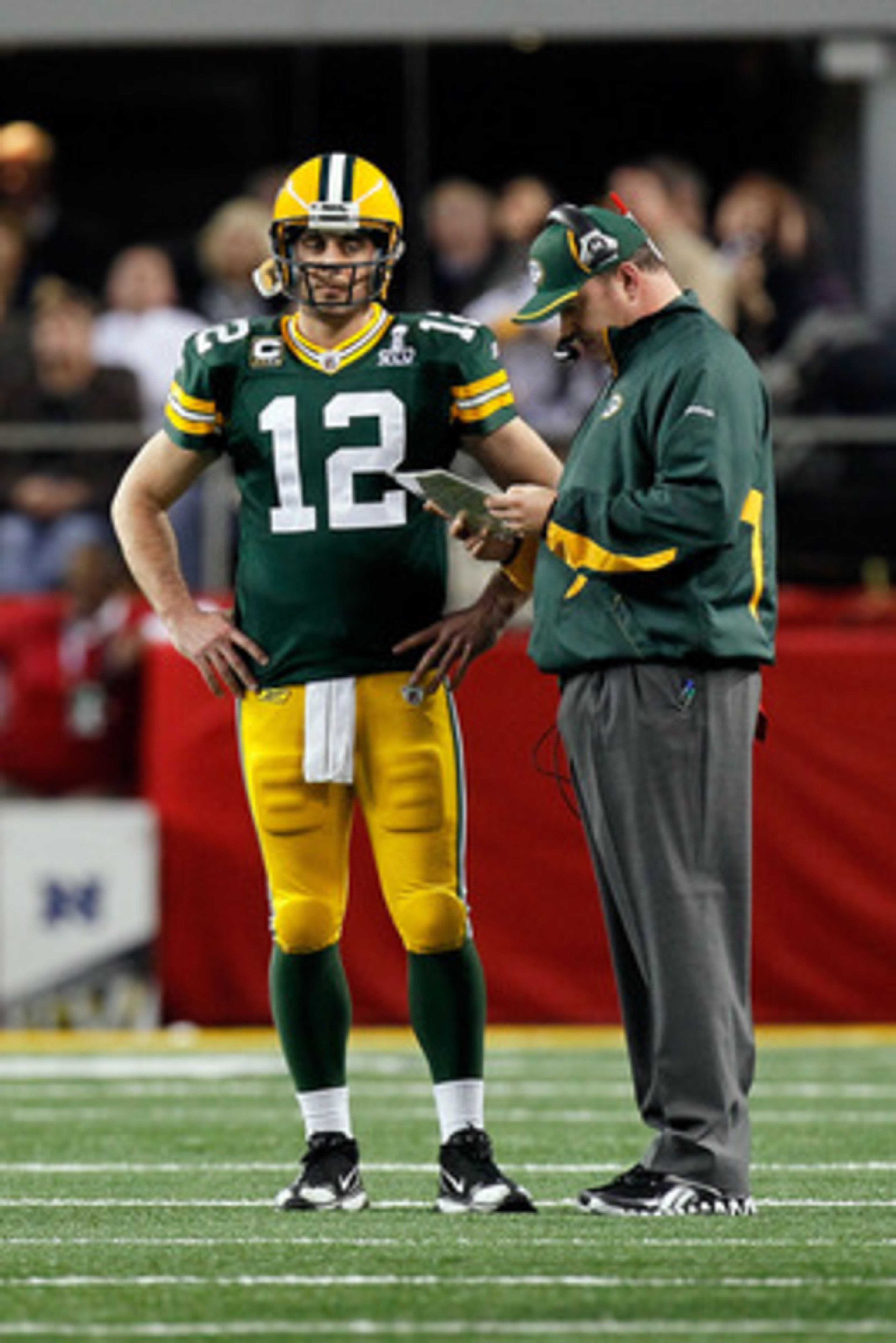 ARLINGTON, TX - FEBRUARY 06:  Aaron Rodgers #12 and head coach Mike McCarthy of the Green Bay Packers talk during a stop in play against the Pittsburgh Steelers during Super Bowl XLV at Cowboys Stadium on February 6, 2011 in Arlington, Texas.  (Photo by K