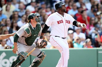 BOSTON, MA - JUNE 04:  David Ortiz #34 of the Boston Red Sox hits a double in the eighth inning as Landon Powell #11 of the Oakland Athletics catches on June 4, 2011 at Fenway Park in Boston, Massachusetts.  (Photo by Elsa/Getty Images)