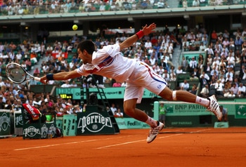 PARIS, FRANCE - JUNE 03:  Novak Djokovic of Serbia stretches to hit a backhand during the men's singles semi final match between Roger Federer of Switzerland and Novak Djokovic of Serbia on day thirteen of the French Open at Roland Garros on June 3, 2011 