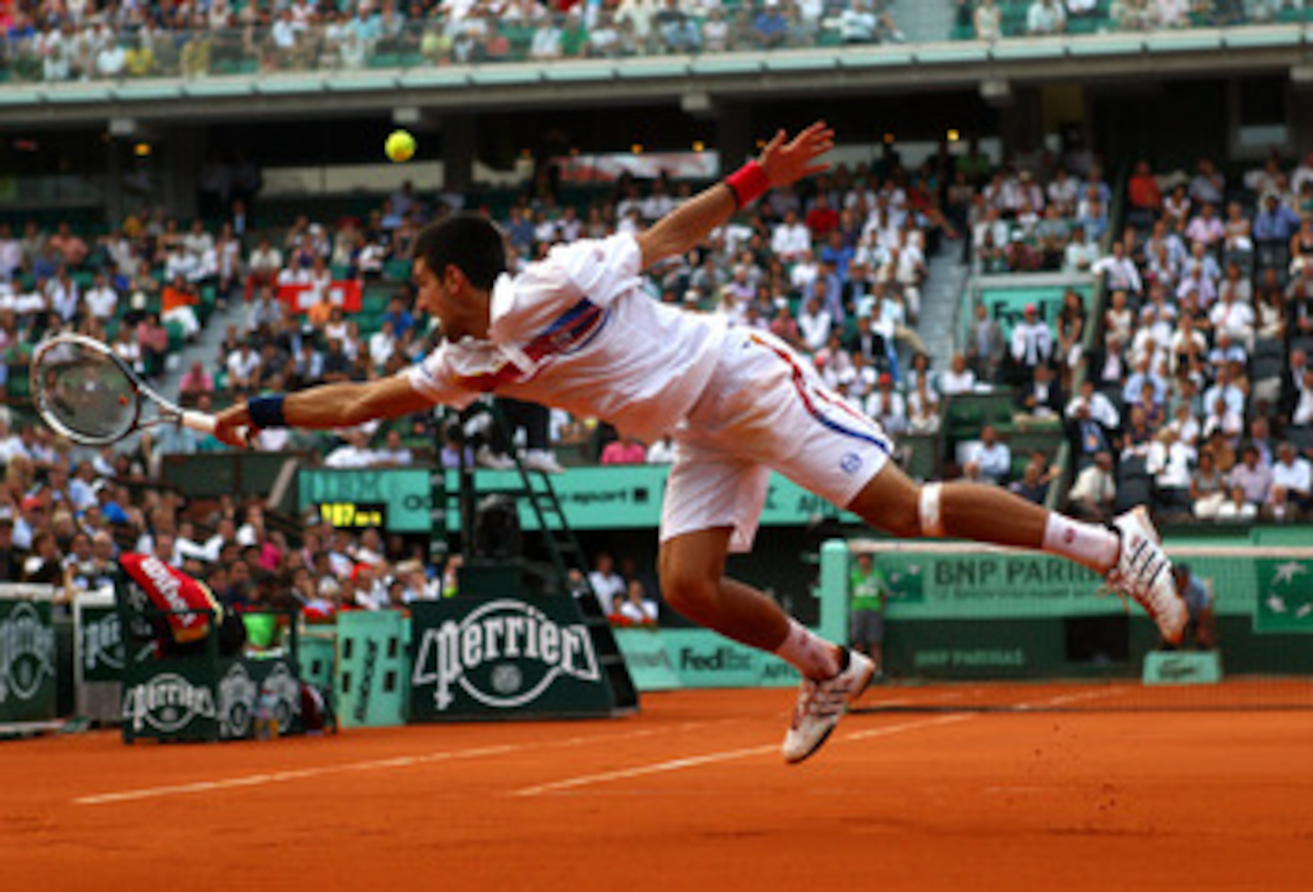 PARIS, FRANCE - JUNE 03:  Novak Djokovic of Serbia stretches to hit a backhand during the men's singles semi final match between Roger Federer of Switzerland and Novak Djokovic of Serbia on day thirteen of the French Open at Roland Garros on June 3, 2011 