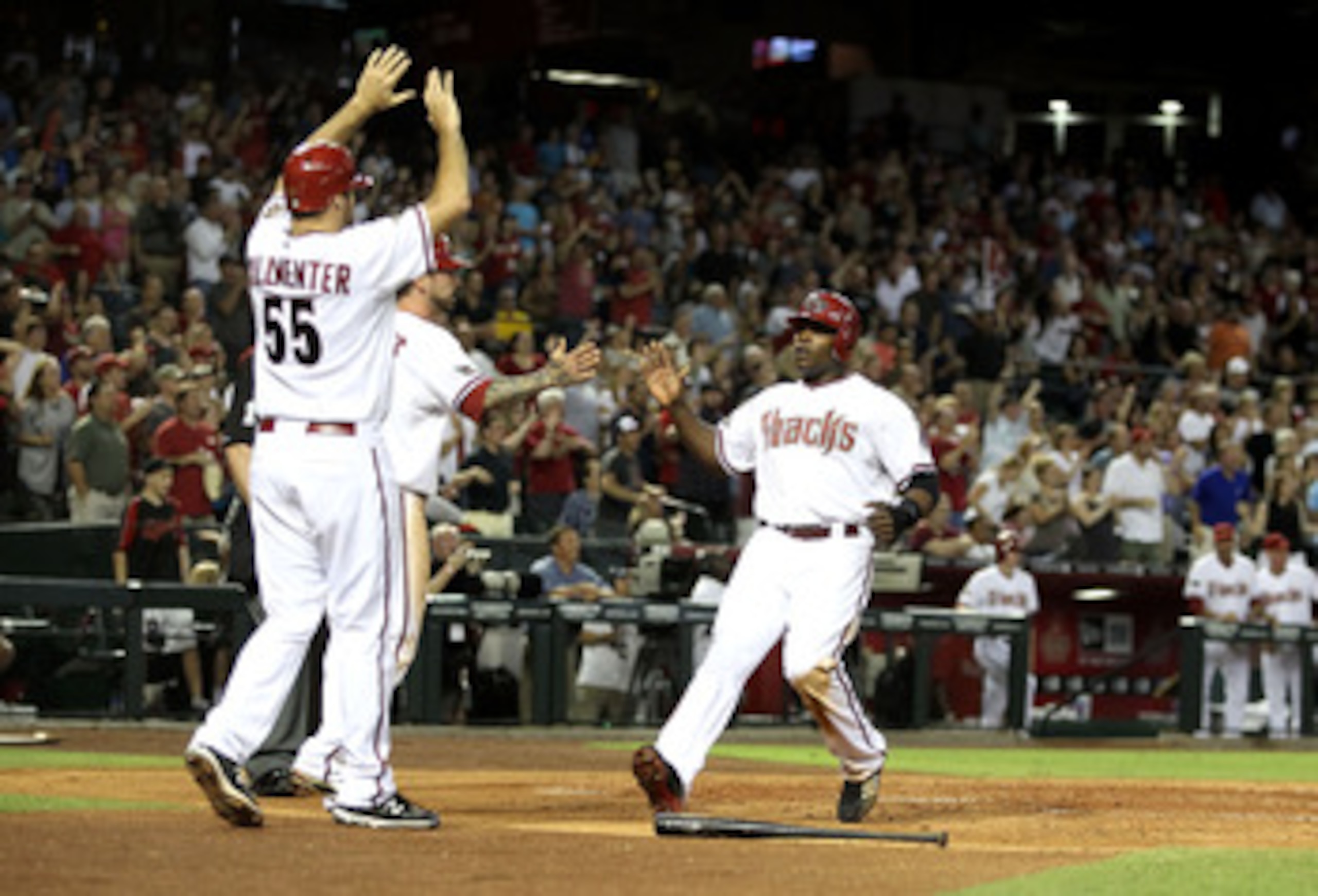 PHOENIX, AZ - JUNE 03:  Justin Upton #10 of the Arizona Diamondbacks high fives teammates Josh Collmenter #55 and Ryan Roberts #14 after all scored on a triple hit by Stephen Drew (not pictured) during the fifth inning of the Major League Baseball game ag