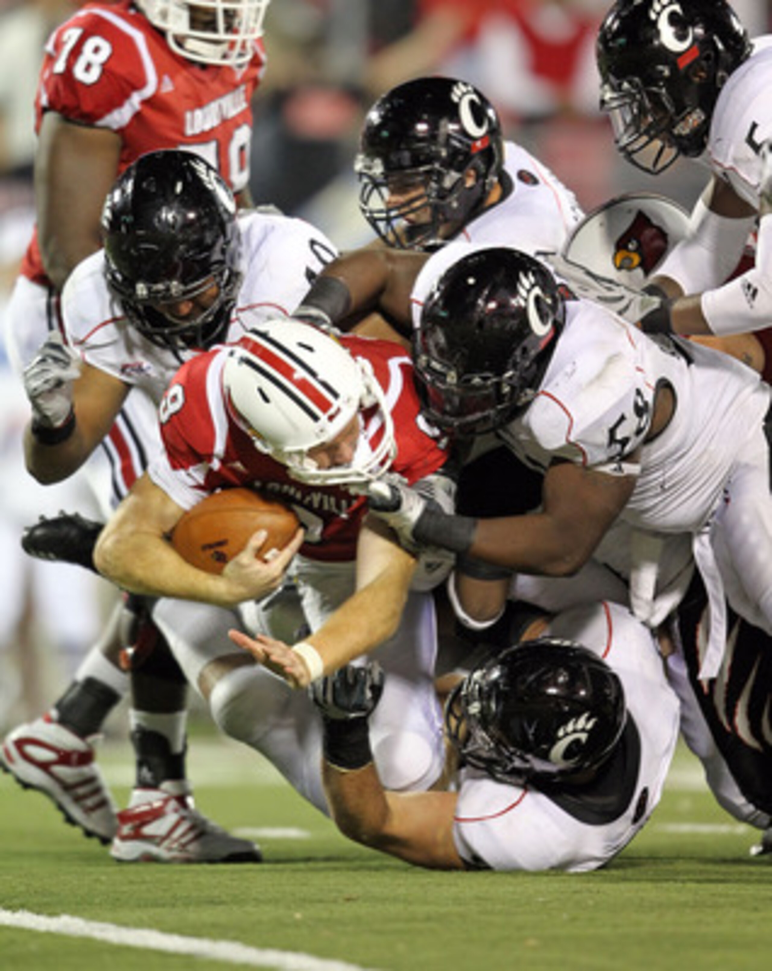 LOUISVILLE, KY - OCTOBER 15: Adam Froman #9 of the Louisville Cardinals is tackled by the Cincinnati Bearcats defense during the 35-27 Cincinnati victory at Papa John's Cardinal Stadium on October 15, 2010 in Louisville, Kentucky. (Photo by Andy Lyons/ LOUISVILLE, KY - OCTOBER 15: Adam Froman #9 of the Louisville Cardinals is tackled by the Cincinnati Bearcats defense during the 35-27 Cincinnati victory at Papa John's Cardinal Stadium on October 15, 2010 in Louisville, Kentucky. (Photo by Andy Lyons/