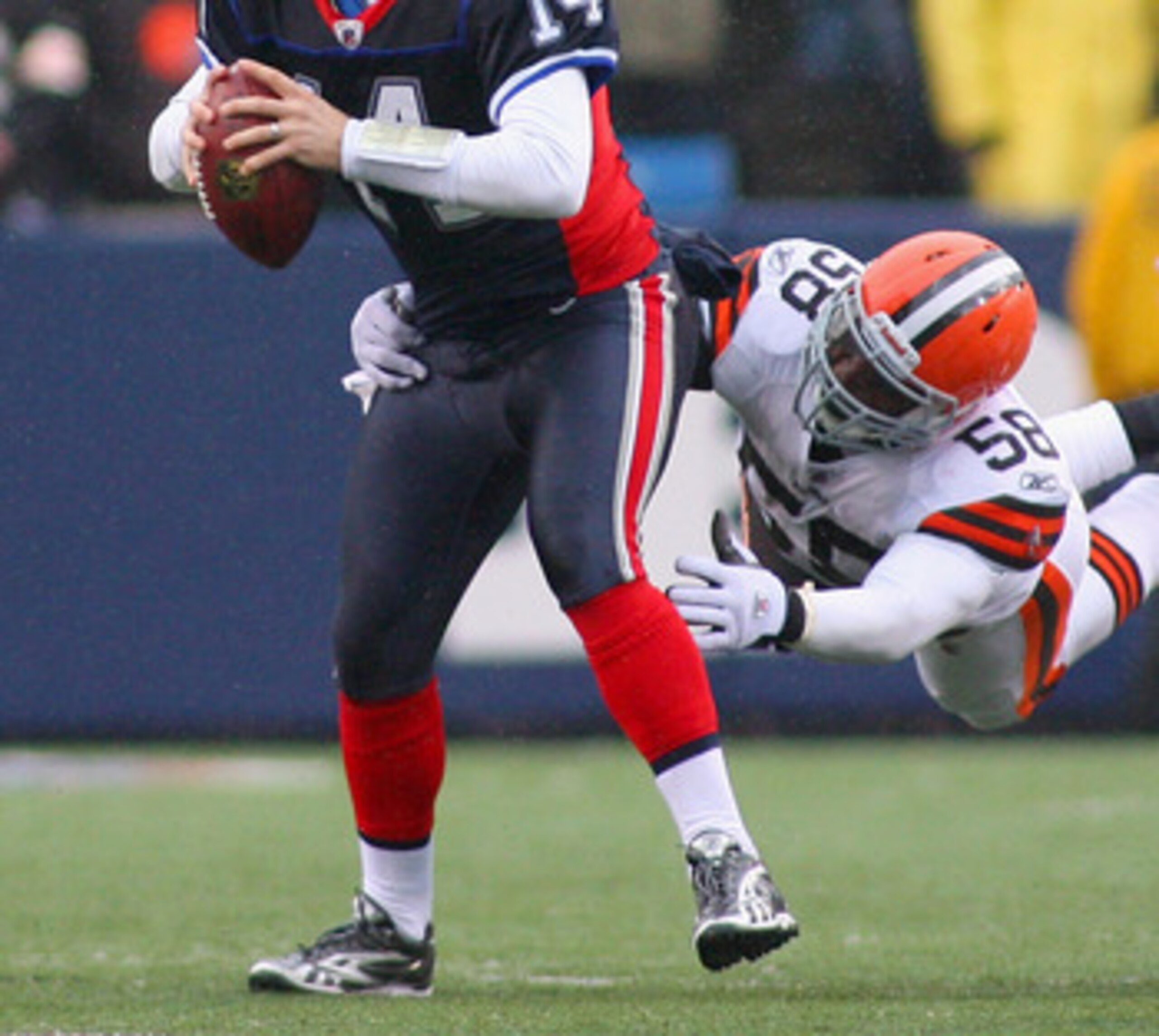 ORCHARD PARK, NY - DECEMBER 12:  Ryan Fitzpatrick #14 of the Buffalo Bills looks to pass with pressure from Marcus Benard #58 of the Cleveland Browns at Ralph Wilson Stadium on December 12, 2010 in Orchard Park, New York. Buffalo won 13-6.  (Photo by Rick