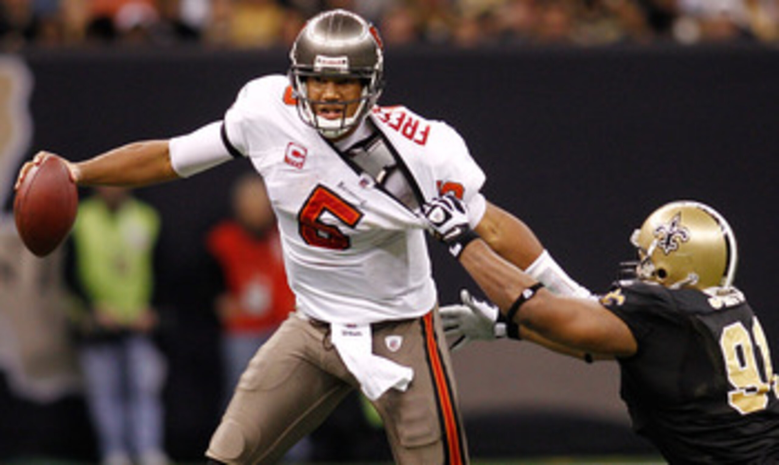 NEW ORLEANS, LA - JANUARY 02: Quarterback Josh Freeman #5 of the Tampa Bay Buccaneers avoids a tackle by Will Smith #91 of the New Orleans Saints at the Louisiana Superdome on January 2, 2011 in New Orleans, Louisiana. The Buccaneers defeated the Saint NEW ORLEANS, LA - JANUARY 02: Quarterback Josh Freeman #5 of the Tampa Bay Buccaneers avoids a tackle by Will Smith #91 of the New Orleans Saints at the Louisiana Superdome on January 2, 2011 in New Orleans, Louisiana. The Buccaneers defeated the Saint
