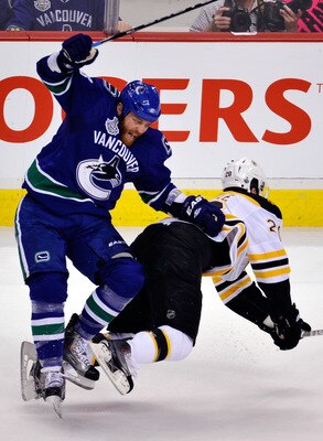 VANCOUVER, BC - JUNE 04:  Raffi Torres #13 of the Vancouver Canucks falls over Daniel Paille #20 of the Boston Bruins during Game Two of the 2011 NHL Stanley Cup Final at Rogers Arena on June 4, 2011 in Vancouver, British Columbia, Canada.  (Photo by Rich