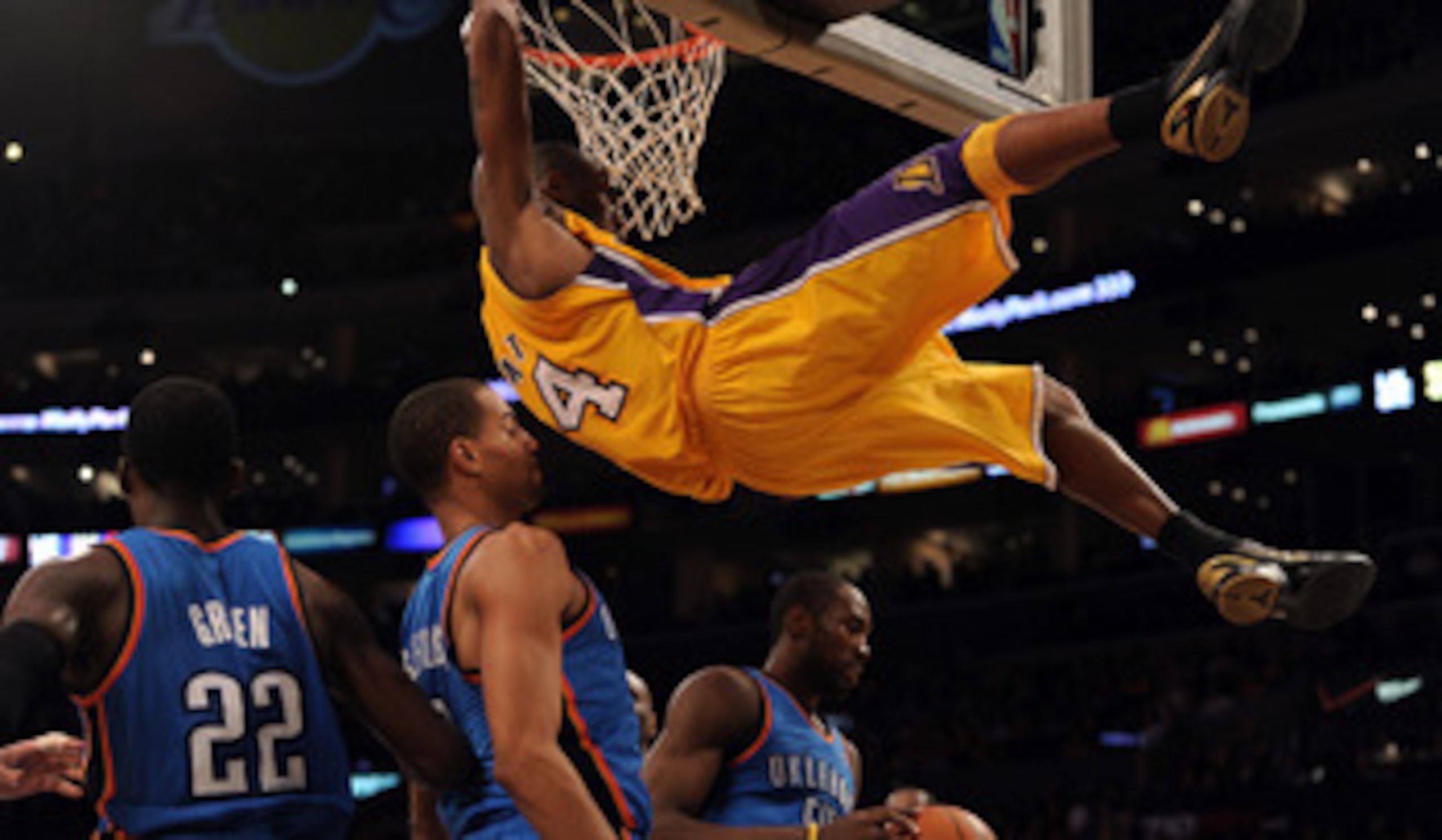 LOS ANGELES, CA - JANUARY 17:  Kobe Bryant #24 of the Los Angeles Lakers hangs on to the rim after his dunk in front of Serge Ibaka #9,Thabo Sefolosha #2 and Jeff Green #22 of the Oklahoma City Thunder at the Staples Center on January 17, 2011 in Los Ange