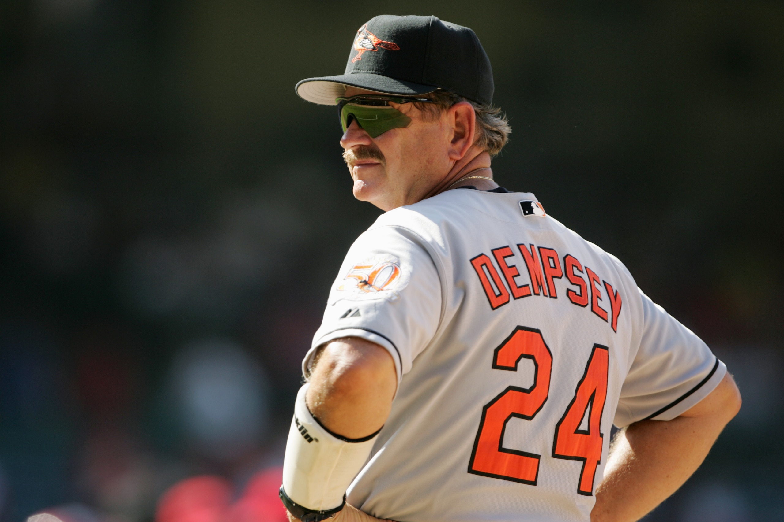 ANAHEIM, CA - AUGUST 12:  First base coach Rick Dempsey #24 of the Baltimore Orioles looks on the field during the game against the Anaheim Angels on August 12, 2004 at Angel Stadium in Anaheim, California.  The Orioles won 6-1.  (Photo by Stephen Dunn/Ge