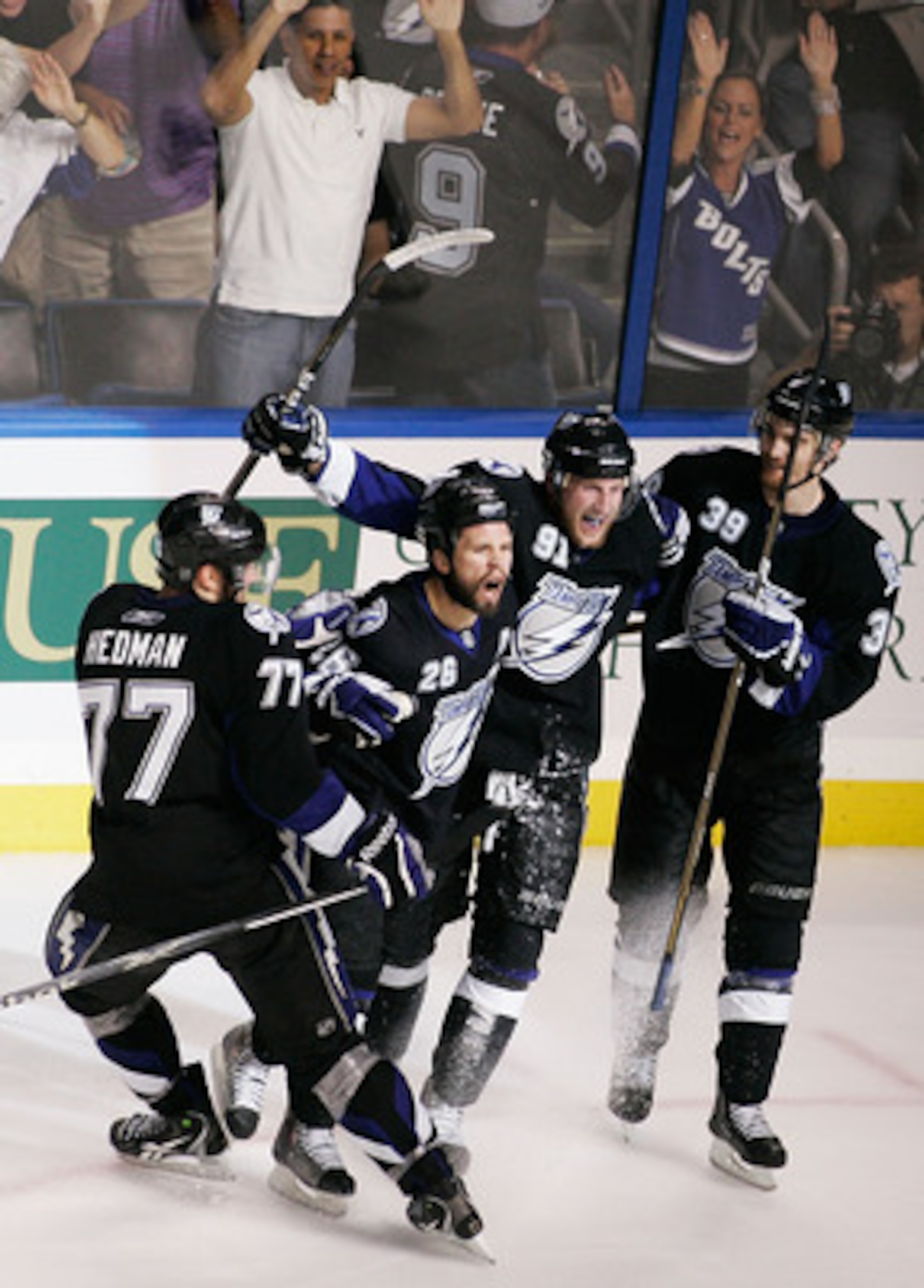 TAMPA, FL - MAY 25:  Martin St. Louis #26 of the Tampa Bay Lightning celebrates his second period goal with teammates in Game Six of the Eastern Conference Finals against the Boston Bruins during the 2011 NHL Stanley Cup Playoffs at St Pete Times Forum on