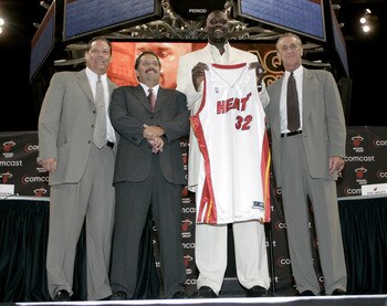 MIAMI - JULY 20:  Shaquille O'Neal of the Miami Heat holds up his new #32 jersey with President and General Manager Randy Pfund (L), Coach Stan Van Gundy (2nd-L) and Pat Riley (R) standing with him during a press conference to offically announce his arriv