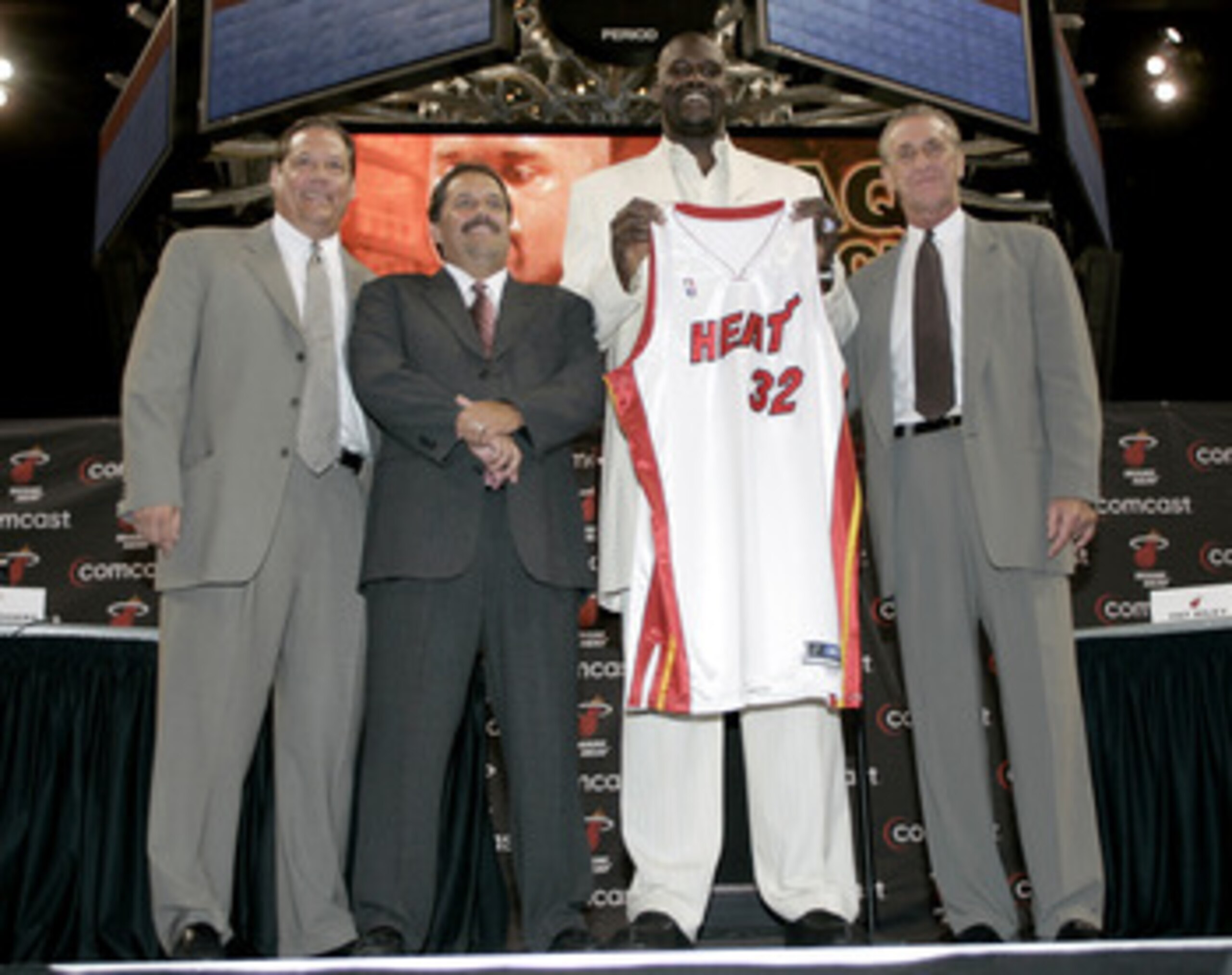 MIAMI - JULY 20:  Shaquille O'Neal of the Miami Heat holds up his new #32 jersey with President and General Manager Randy Pfund (L), Coach Stan Van Gundy (2nd-L) and Pat Riley (R) standing with him during a press conference to offically announce his arriv