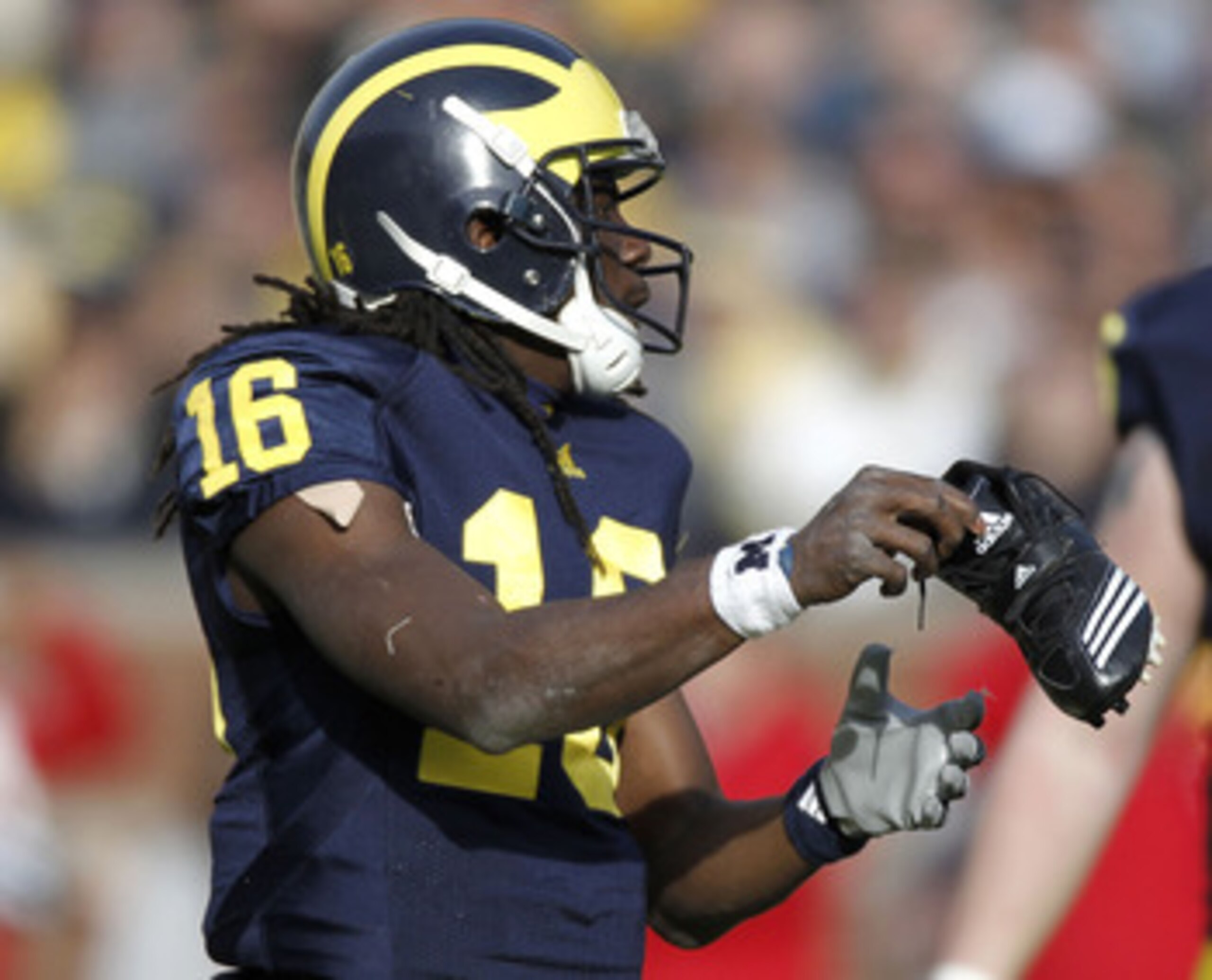 ANN ARBOR, MI - NOVEMBER 20:  Denard Robinson #16 of the Michigan Wolverines puts his shoe back on while playing the Wisconsin Badgers tackles at Michigan Stadium on November 20, 2010 in Ann Arbor, Michigan. Wisconsin won the game 48-38.  (Photo by Gregor