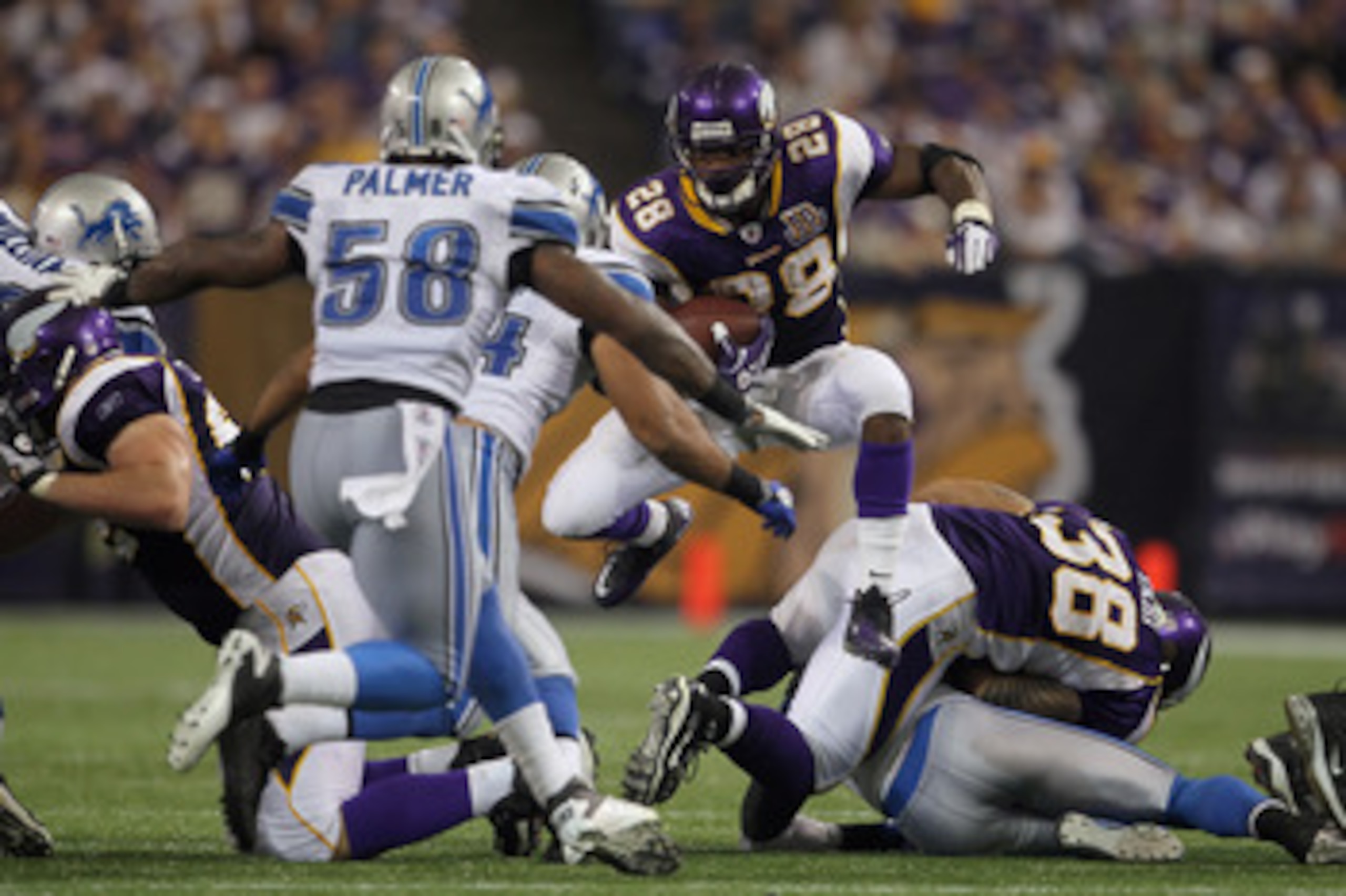 MINNEAPOLIS - SEPTEMBER 26:  Running back Adrian Peterson #28 of the Minnesota Vikings jumps through a hole while carrying the ball against the Detroit Lions during the second half at Mall of America Field on September 26, 2010 in Minneapolis, Minnesota.
