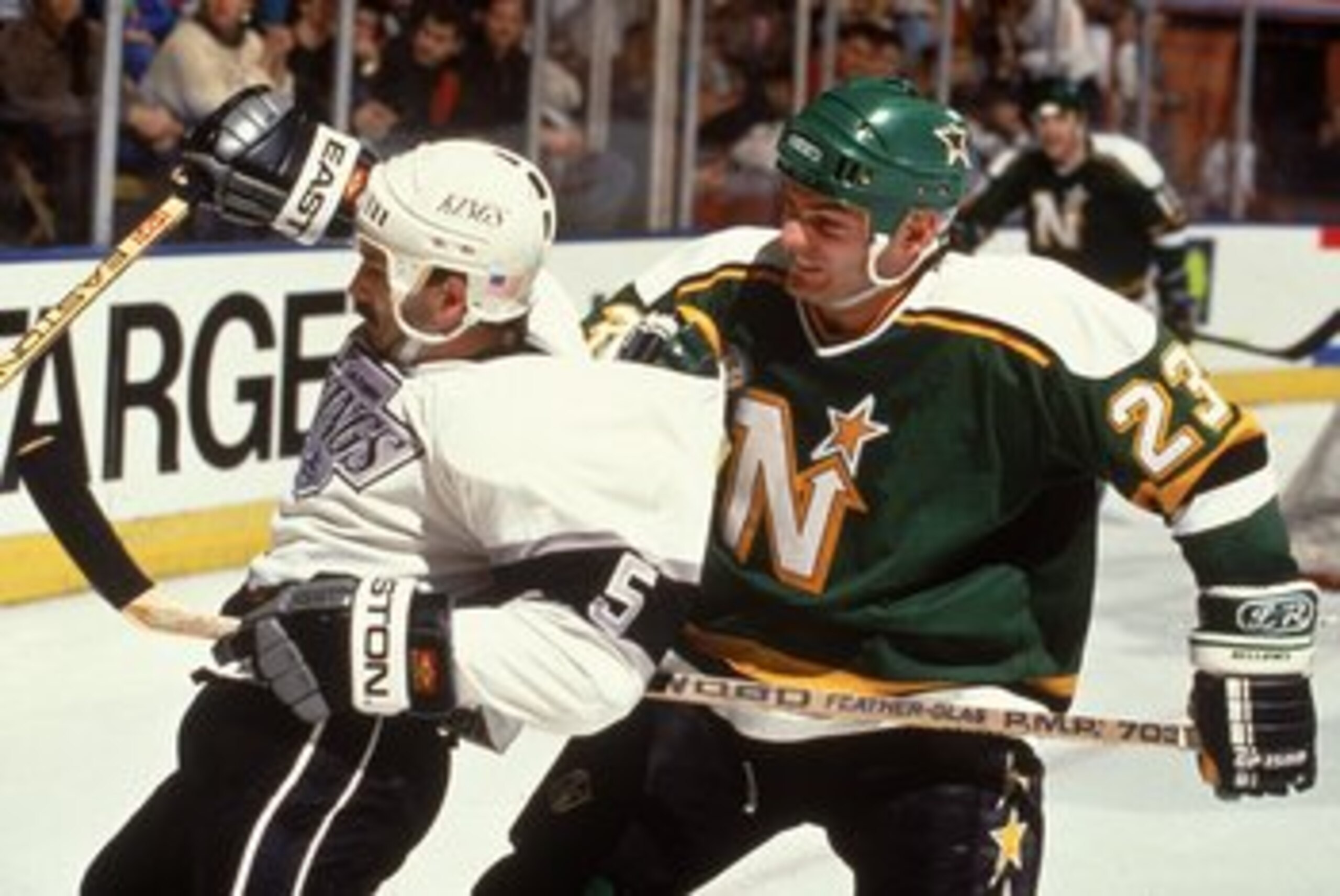 Brian Bellows #23 of the Minnesota North Stars comes up behind Tim Watters #5 of the Los Angeles Kings during a game.