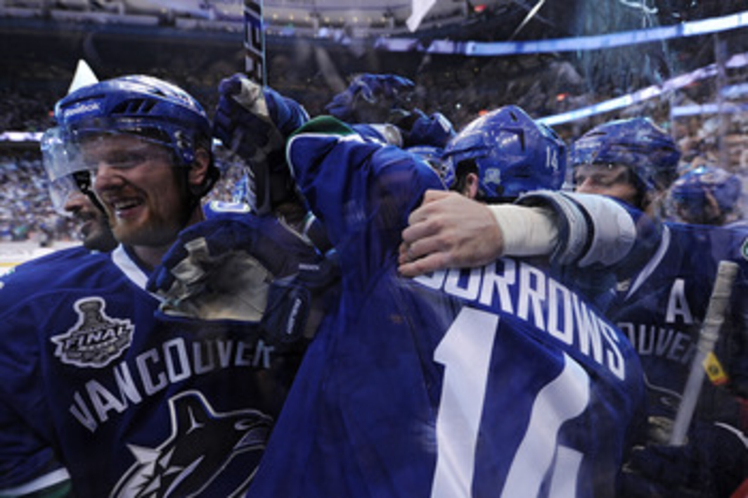 VANCOUVER, BC - JUNE 04:  Alex Burrows #14 of the Vancouver Canucks celebrates with his teammates after scoring a goal in overtime against Zdeno Chara #33 and Tim Thomas #30 of the Boston Bruins to win Game Two of the 2011 NHL Stanley Cup Final at Rogers 
