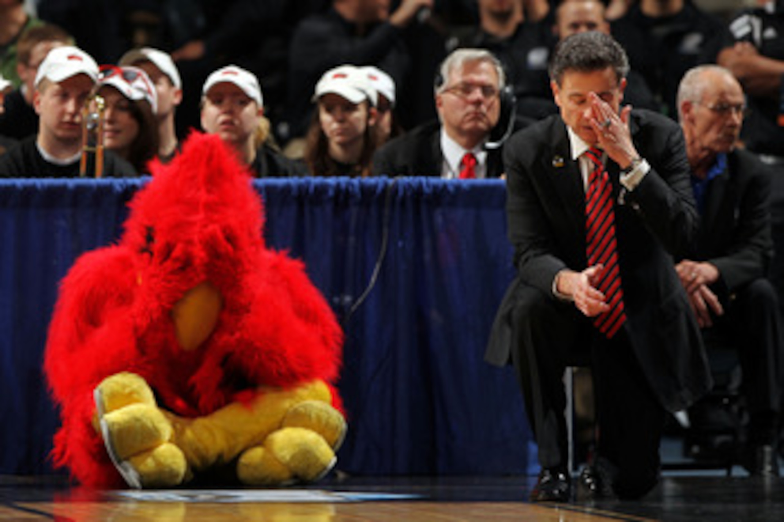 DENVER, CO - MARCH 17:  Head coach Rick Pitino of the Louisville Cardinals and the teams mascot react after a play while playing against the Morehead State Eagles during the second round of the 2011 NCAA men's basketball tournament at Pepsi Center on Marc