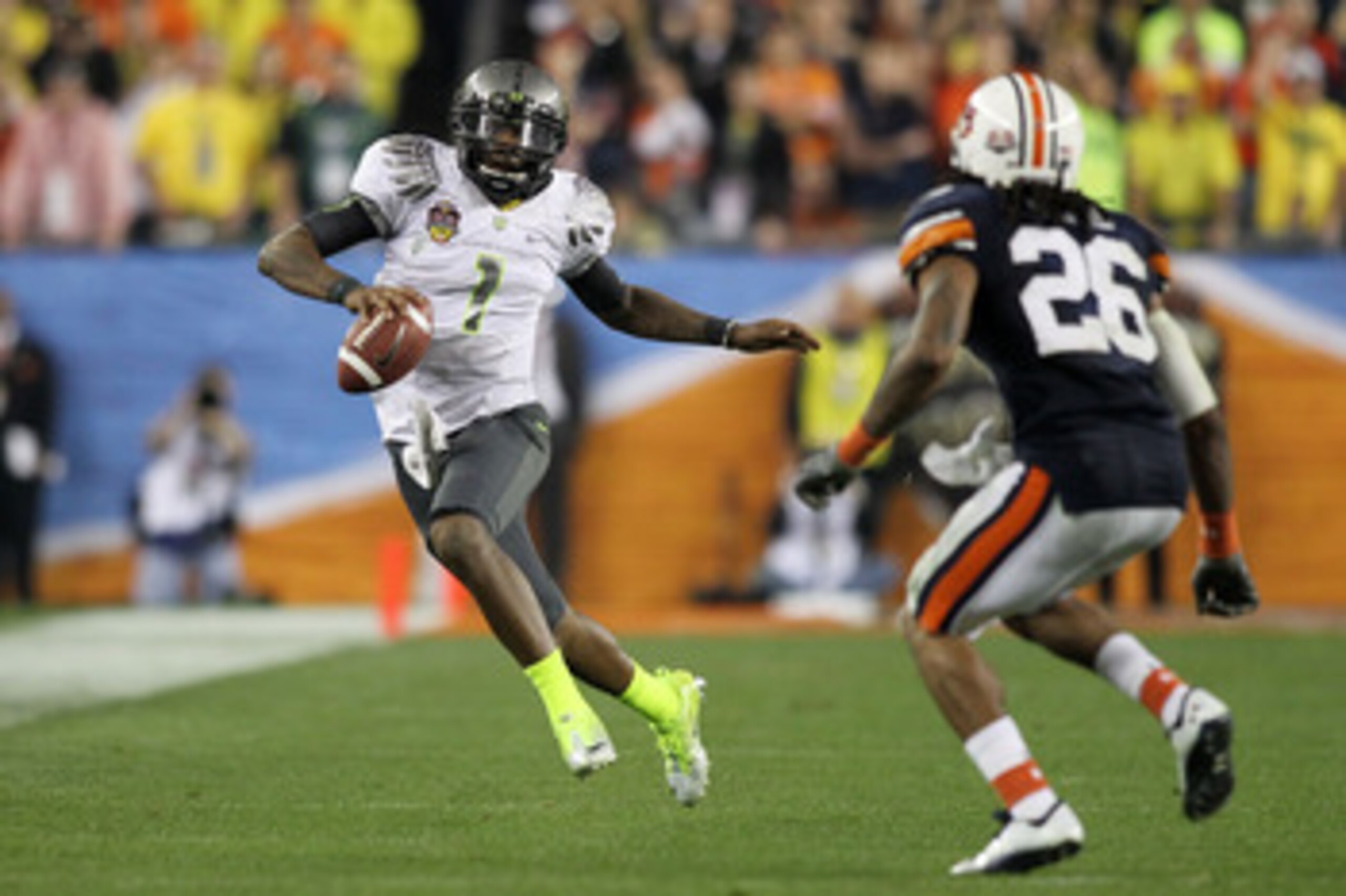 GLENDALE, AZ - JANUARY 10: Darron Thomas #1 of the Oregon Ducks scrambles against Mike McNeil #26 of the Auburn Tigers during the Tostitos BCS National Championship Game at University of Phoenix Stadium on January 10, 2011 in Glendale, Arizona. (Photo b GLENDALE, AZ - JANUARY 10: Darron Thomas #1 of the Oregon Ducks scrambles against Mike McNeil #26 of the Auburn Tigers during the Tostitos BCS National Championship Game at University of Phoenix Stadium on January 10, 2011 in Glendale, Arizona. (Photo b