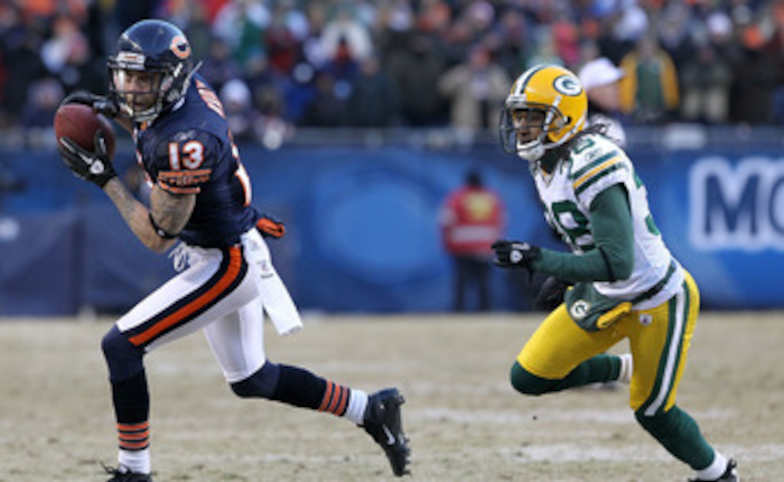 CHICAGO, IL - JANUARY 23:  Johnny Knox #13 of the Chicago Bears runs ahead of Tramon Williams #38 of the Green Bay Packers for a 32-yard gain in the fourth quarter in the NFC Championship Game at Soldier Field on January 23, 2011 in Chicago, Illinois.  (P