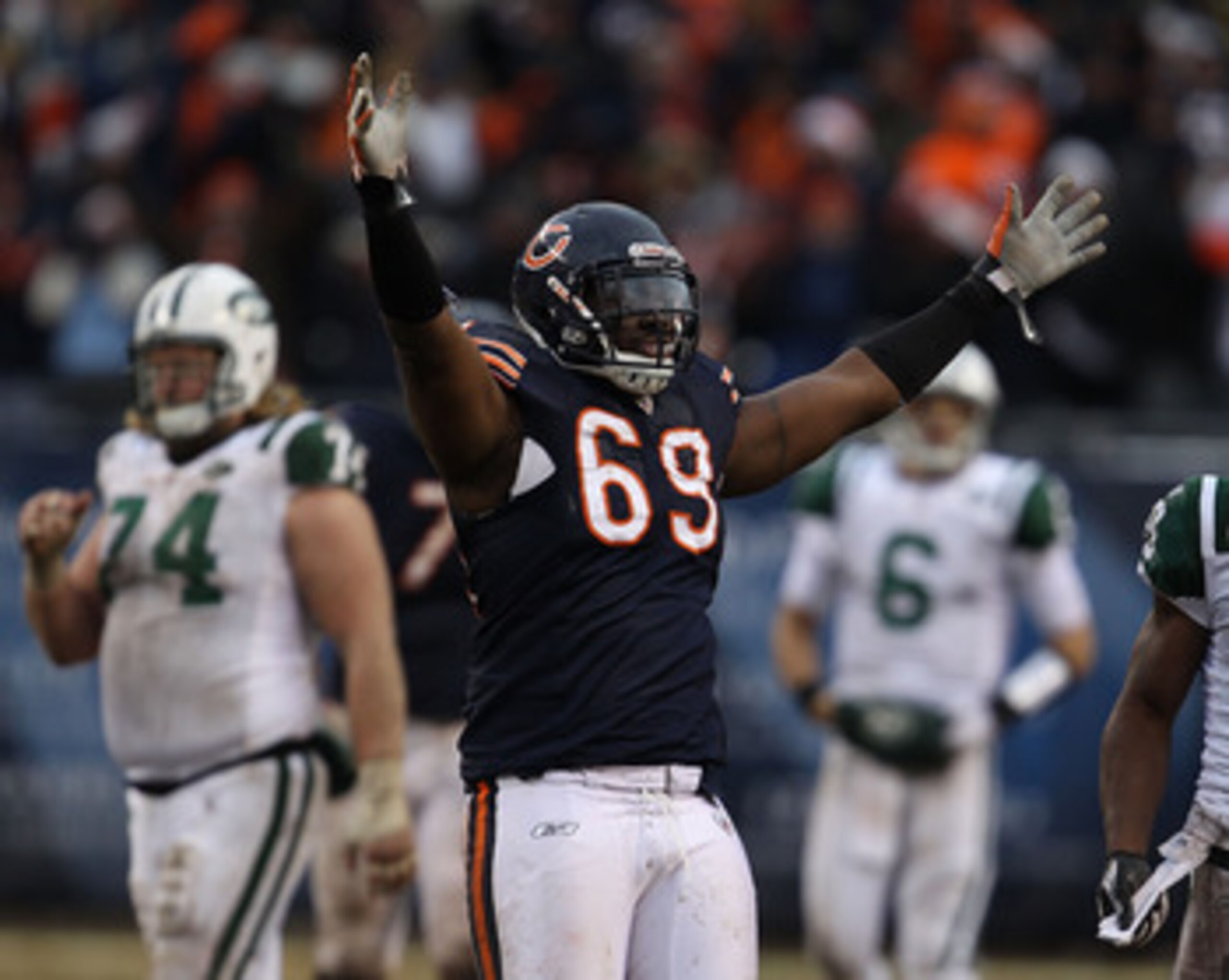 CHICAGO, IL - DECEMBER 26: Henry Melton #69 of the Chicago Bears celebrates after teammate Chris Harris intercepted a pass in the final minutes as Nick Mangold #74 and Mark Sanchez #6 of the New York Jets walk off of the field at Soldier Field on December