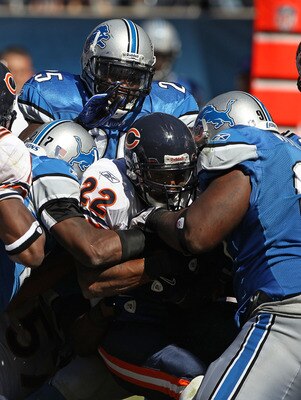 CHICAGO - SEPTEMBER 12: Matt Forte #22 of the Chicago Bears is gang-tackled by (L-R) Alphonso Smith #27, Randy Phillips #25 and Ndamukong Suh #90 of the Detroit Lions during the NFL season opening game at Soldier Field on September 12, 2010 in Chicago, Il