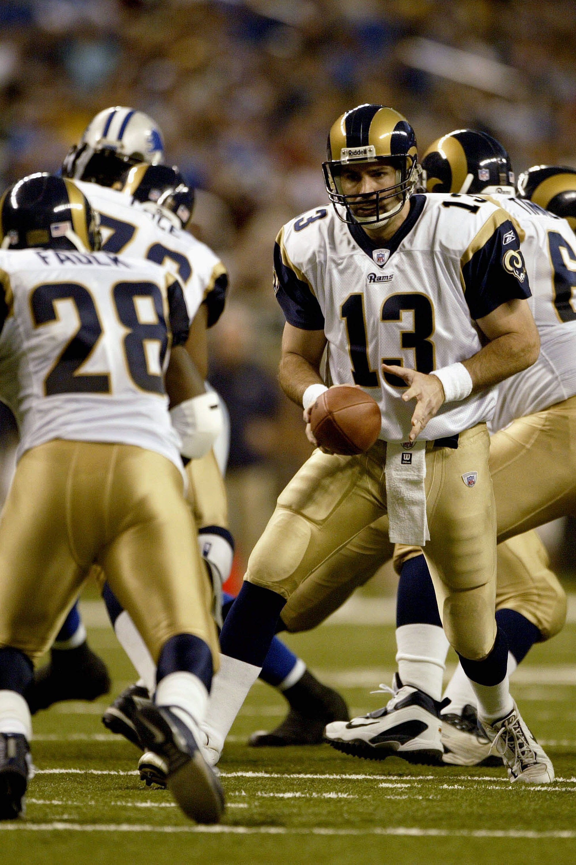 DETROIT - DECEMBER 28:  Quarterback Kurt Warner #13 of the St. Louis Rams hands off to teammate Marshall Faulk #28 against the Detroit Lions in the fourth quarter on December 28, 2003 at Ford Field in Detroit, Michigan. The Lions won 30-20.  (Photo by Har