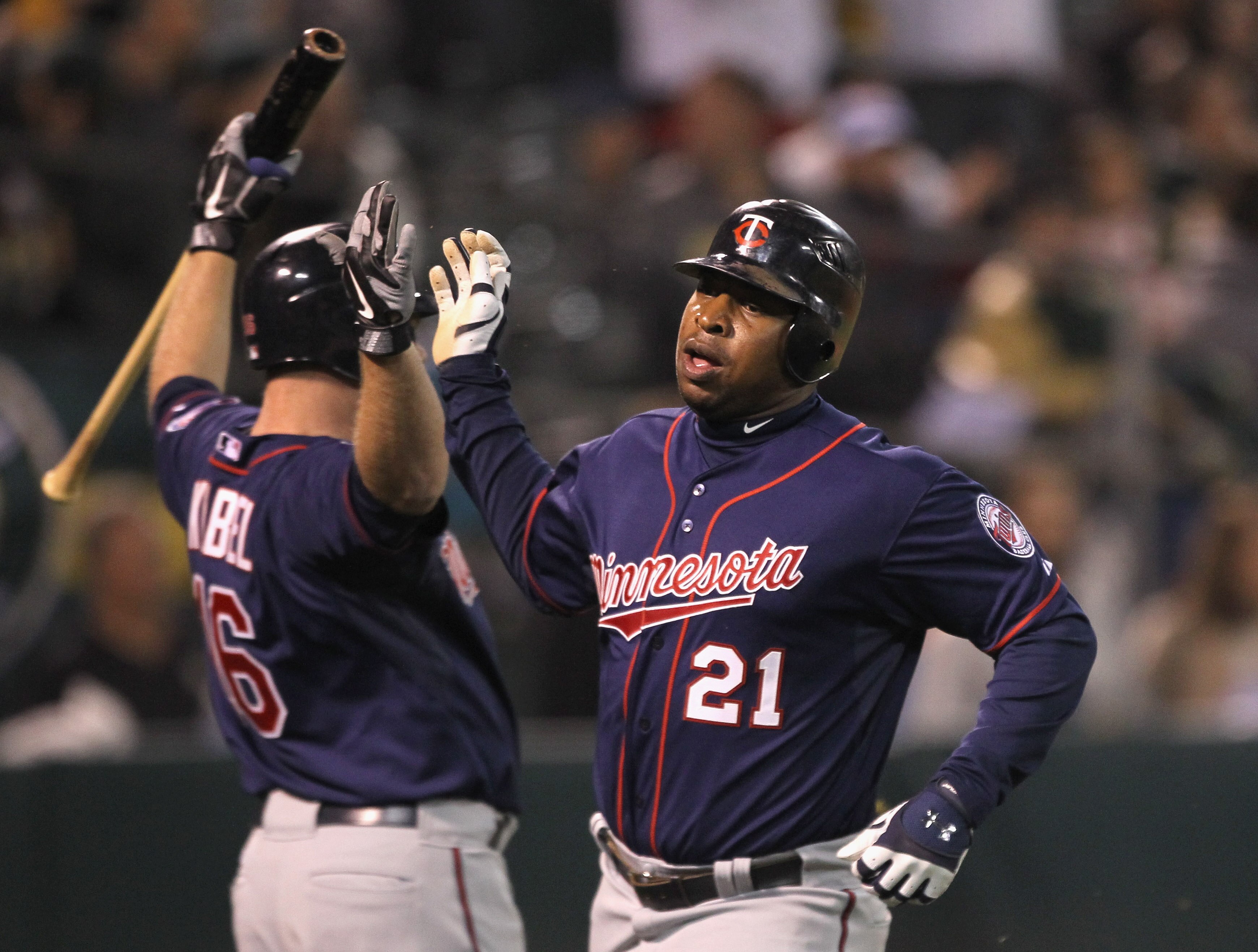 OAKLAND, CA - MAY 18:  Delmon Young #21 of the Minnesota Twins is congratulated by Jason Kubel #16 of the Minnesota Twins after he scored in the 10th inning to give the Twins a 4-3 lead over the Oakland Athletics at Oakland-Alameda County Coliseum on May