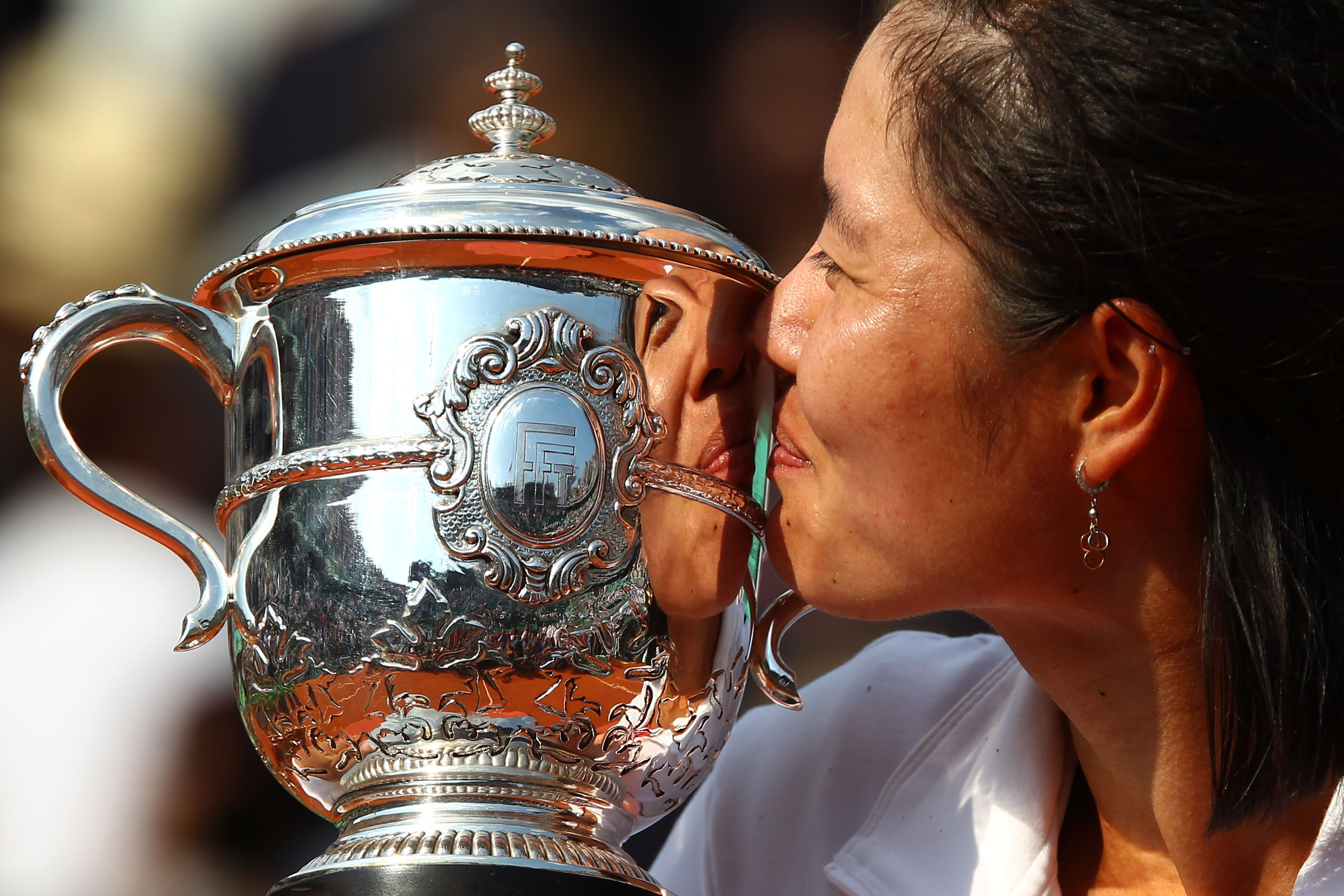 PARIS, FRANCE - JUNE 04:  Na Li of China kisses the trophy following her victory during the women's singles final match between Francesca Schiavone of Italy and Na Li of China on day fourteen of the French Open at Roland Garros on June 4, 2011 in Paris, F
