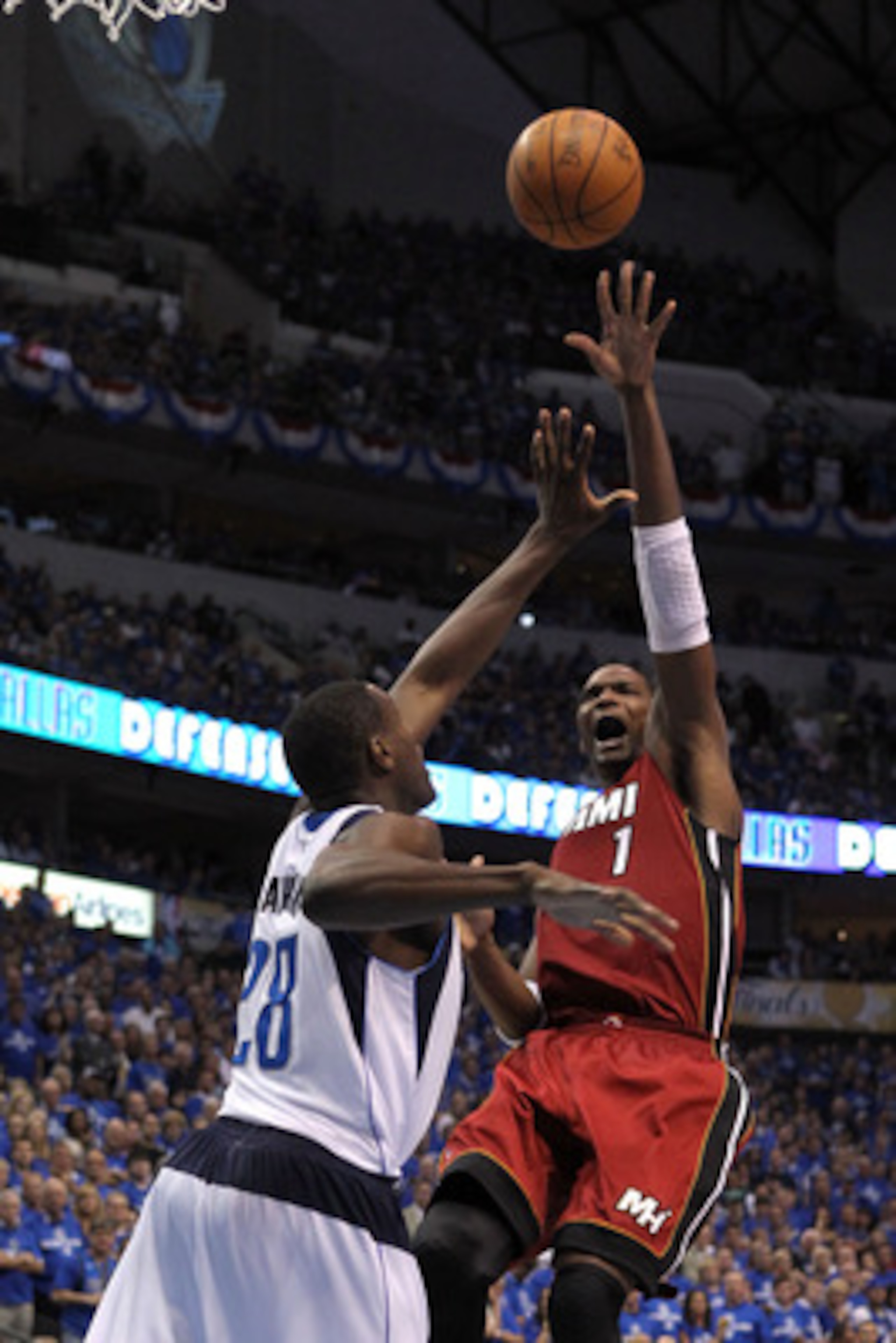 DALLAS, TX - JUNE 05:  Chris Bosh #1 of the Miami Heat attempts a shot against Ian Mahinmi #28 of the Dallas Mavericks in Game Three of the 2011 NBA Finals at American Airlines Center on June 5, 2011 in Dallas, Texas.  NOTE TO USER: User expressly acknowl