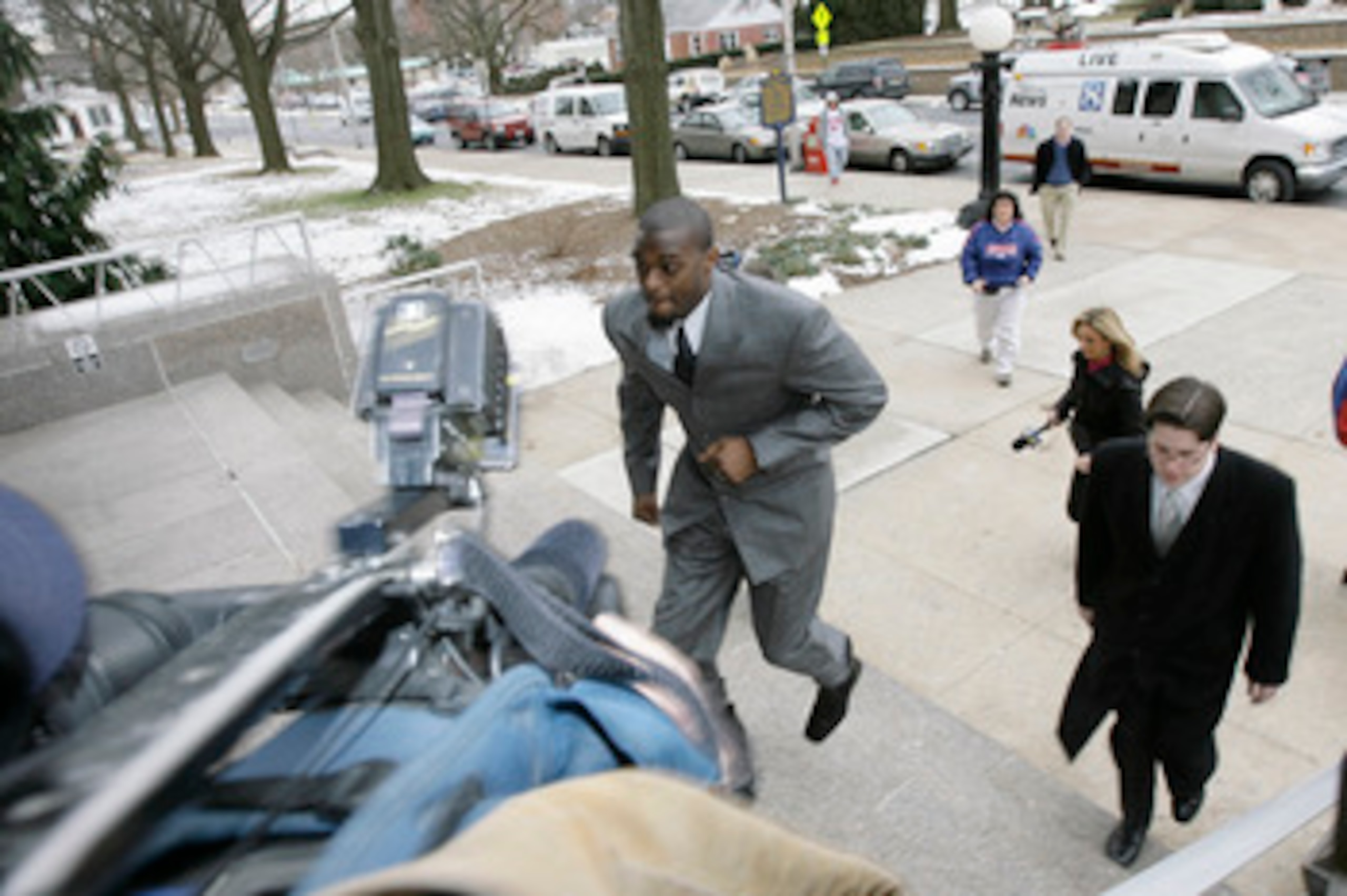 LEBANON - JANUARY 14: New York Giants wide receiver Plaxico Burress runs up the front steps toward members of the media as he arrives at the Lebanon County Courthouse January 14, 2009 in Lebanon, Pa.  Burress is scheduled to appear in a civil trial in a d