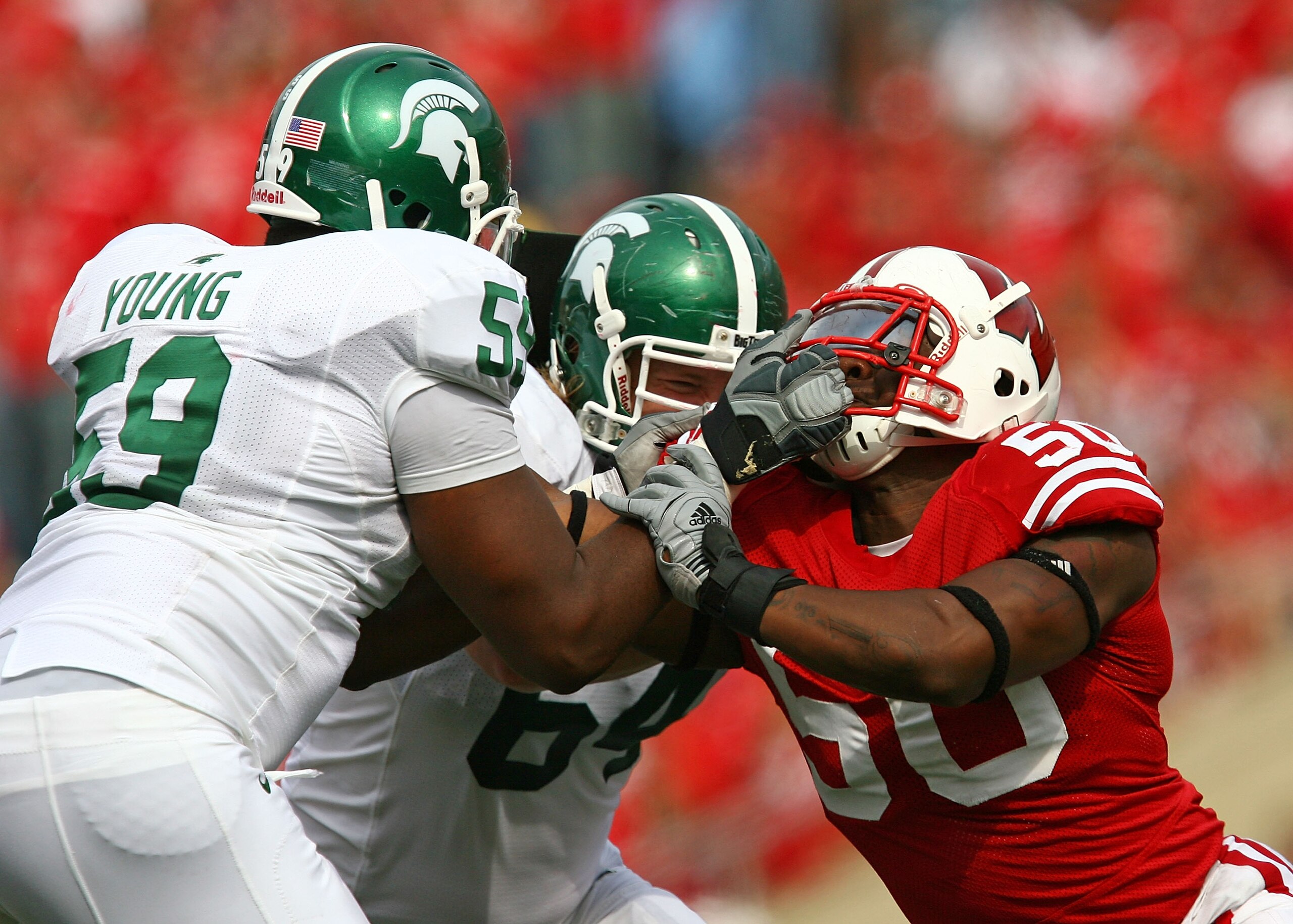 MADISON, WI - SEPTEMBER 26: D.J. Young #59 of the Michigan State Spartans tries to block O'Brien Schofiled #50 of the Wisconsin Badgers by grabbing his face mask on September 26, 2009 at Camp Randall Stadium in Madison, Wisconsin. Wisconsin defeated Michi MADISON, WI - SEPTEMBER 26: D.J. Young #59 of the Michigan State Spartans tries to block O'Brien Schofiled #50 of the Wisconsin Badgers by grabbing his face mask on September 26, 2009 at Camp Randall Stadium in Madison, Wisconsin. Wisconsin defeated Michi